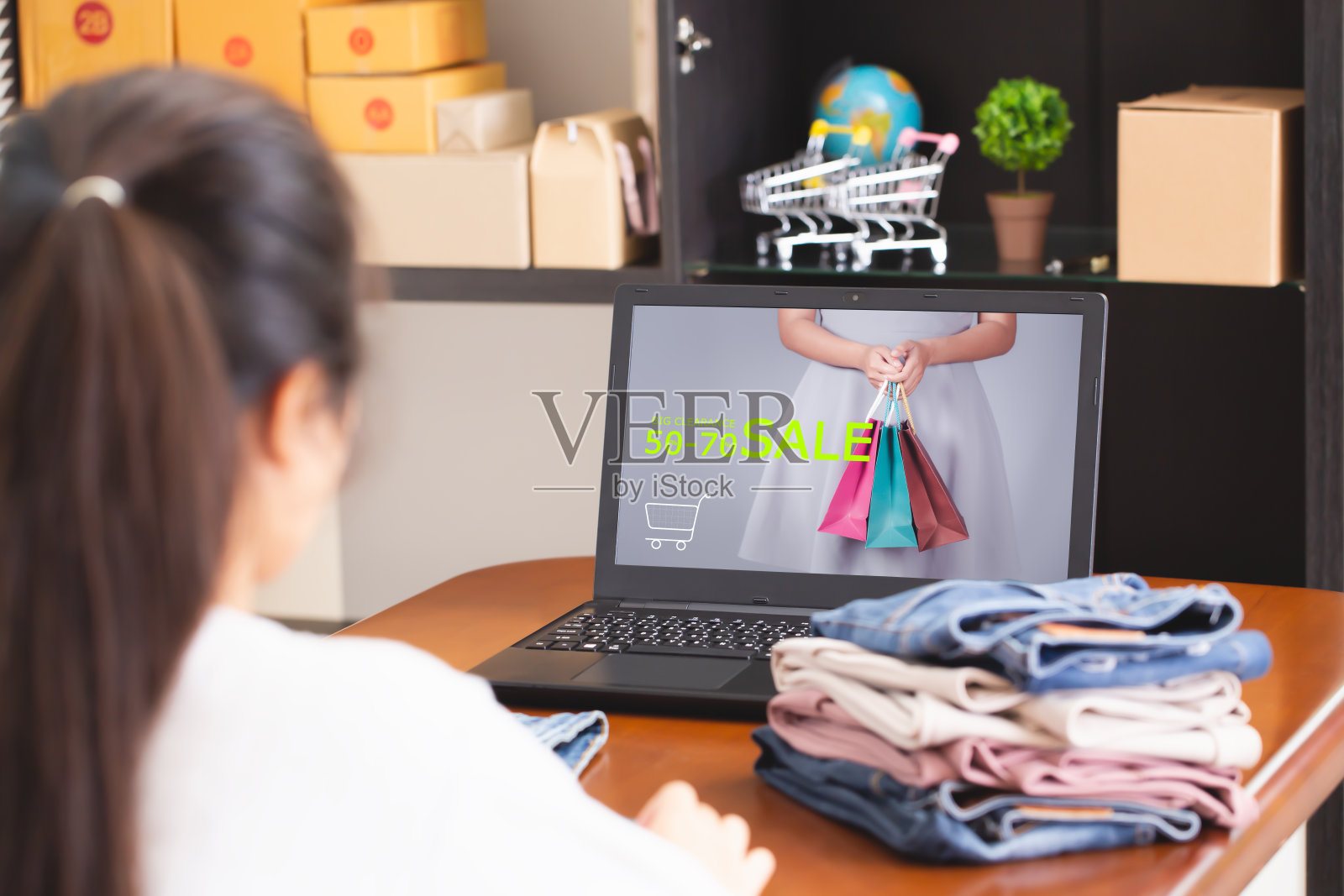 店主正在网上促销，以促进销售。电子交易模式，即允许消费者在网上直接购物的概念。照片摄影图片