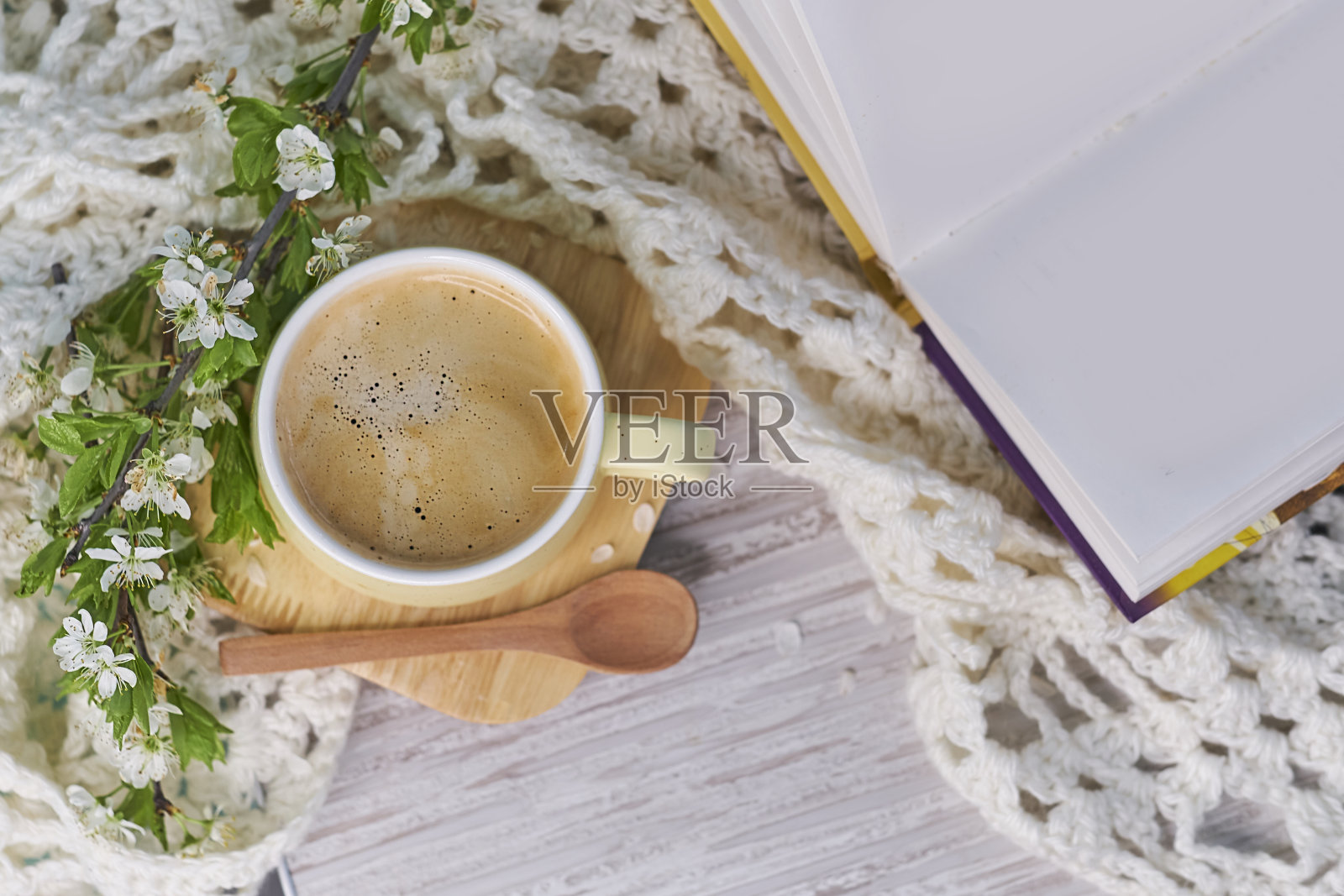 温馨的家居静物:一杯热咖啡，春天的鲜花和打开的书与温暖的格子。春季概念，免费拷贝空间。神奇的焦外成像背景。早上肯定概念照片摄影图片