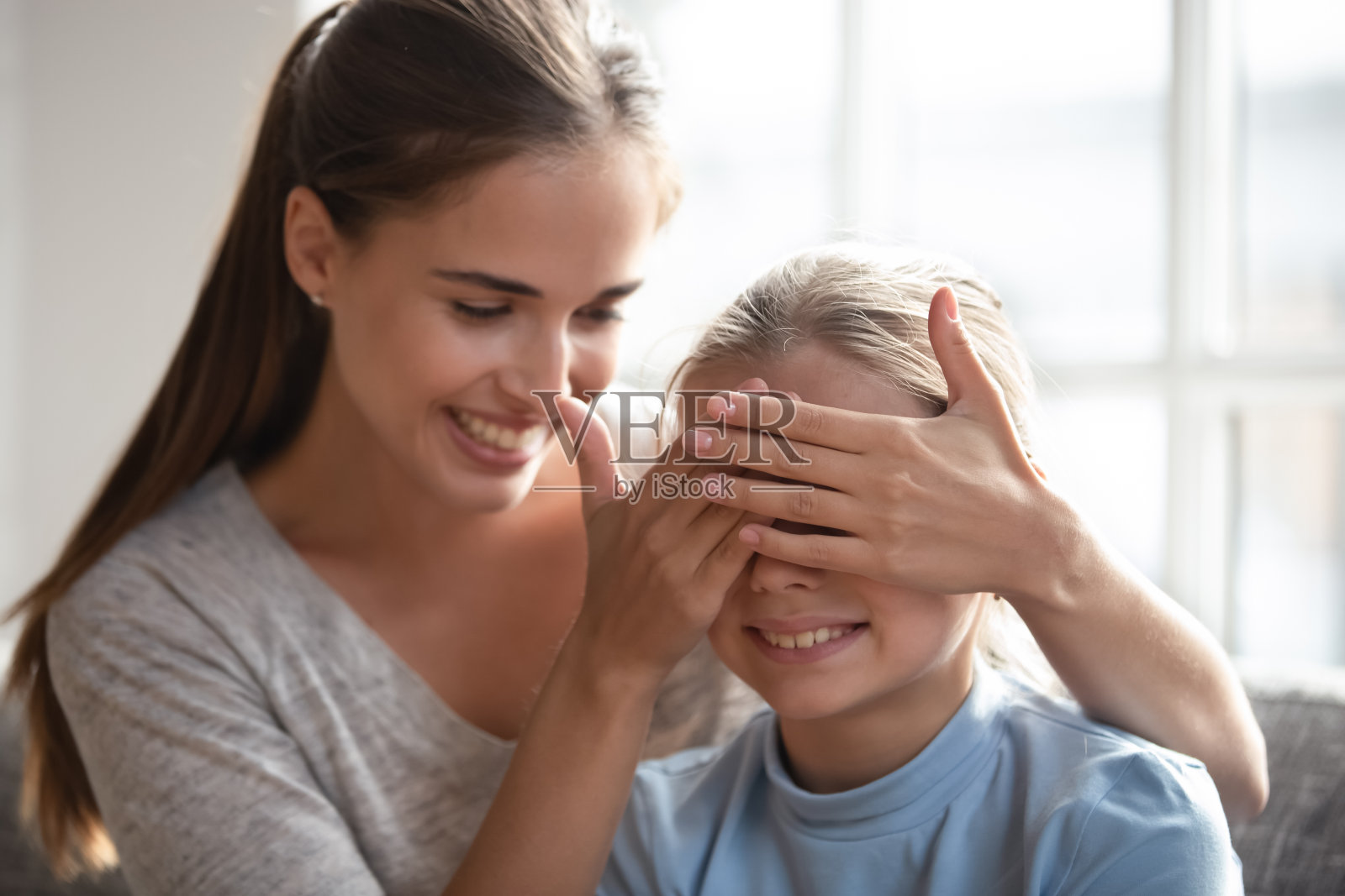 微笑的妈妈在家为女儿做生日惊喜照片摄影图片