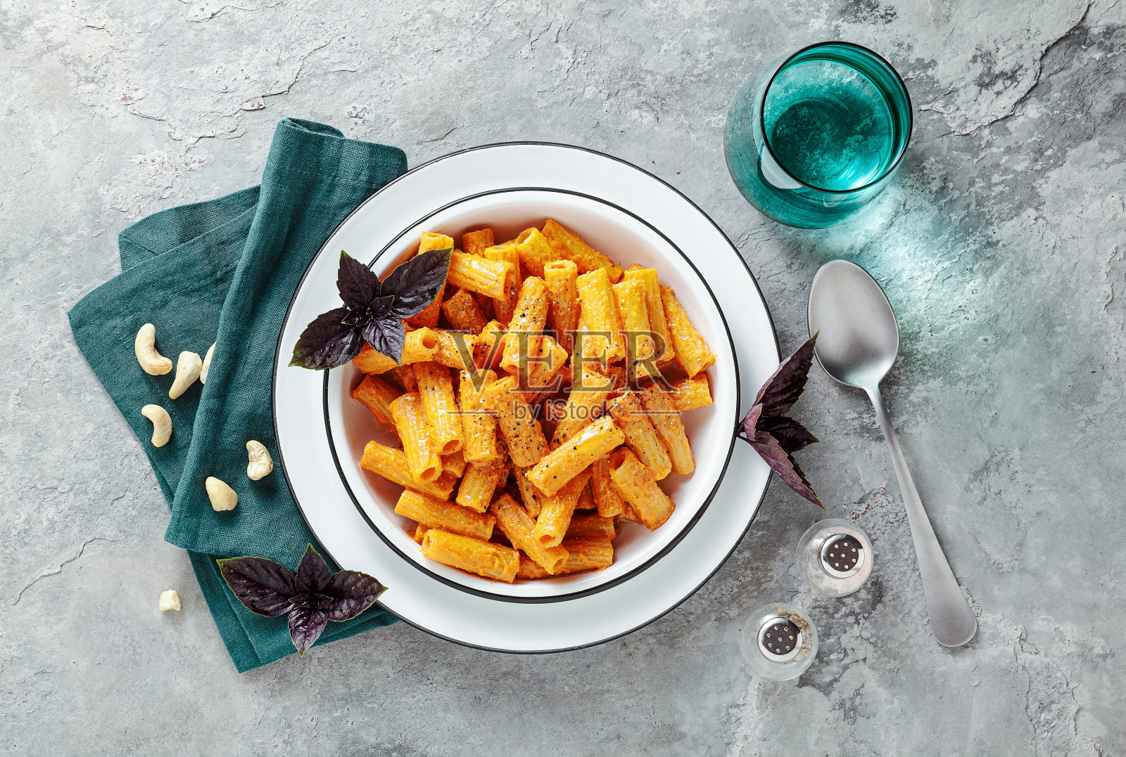 意大利面配烤辣椒和腰果酱。纯素健康午餐或晚餐配紫罗勒照片摄影图片