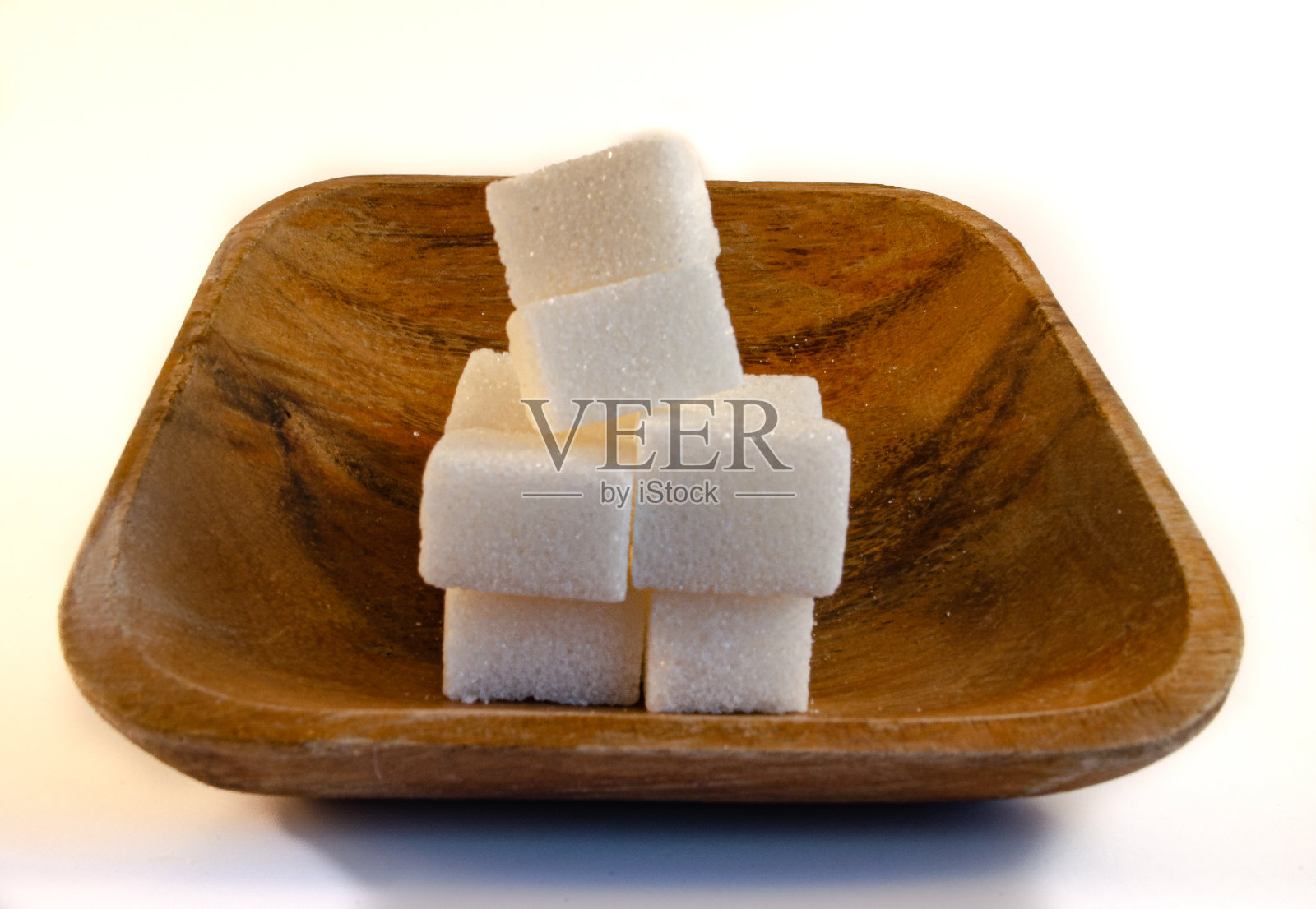 方糖在一个木碗孤立在白色照片摄影图片