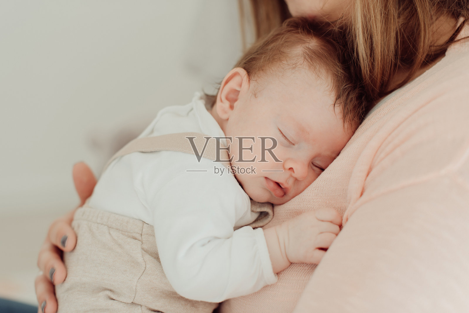 年轻的母亲抱着刚出生的婴儿照片摄影图片