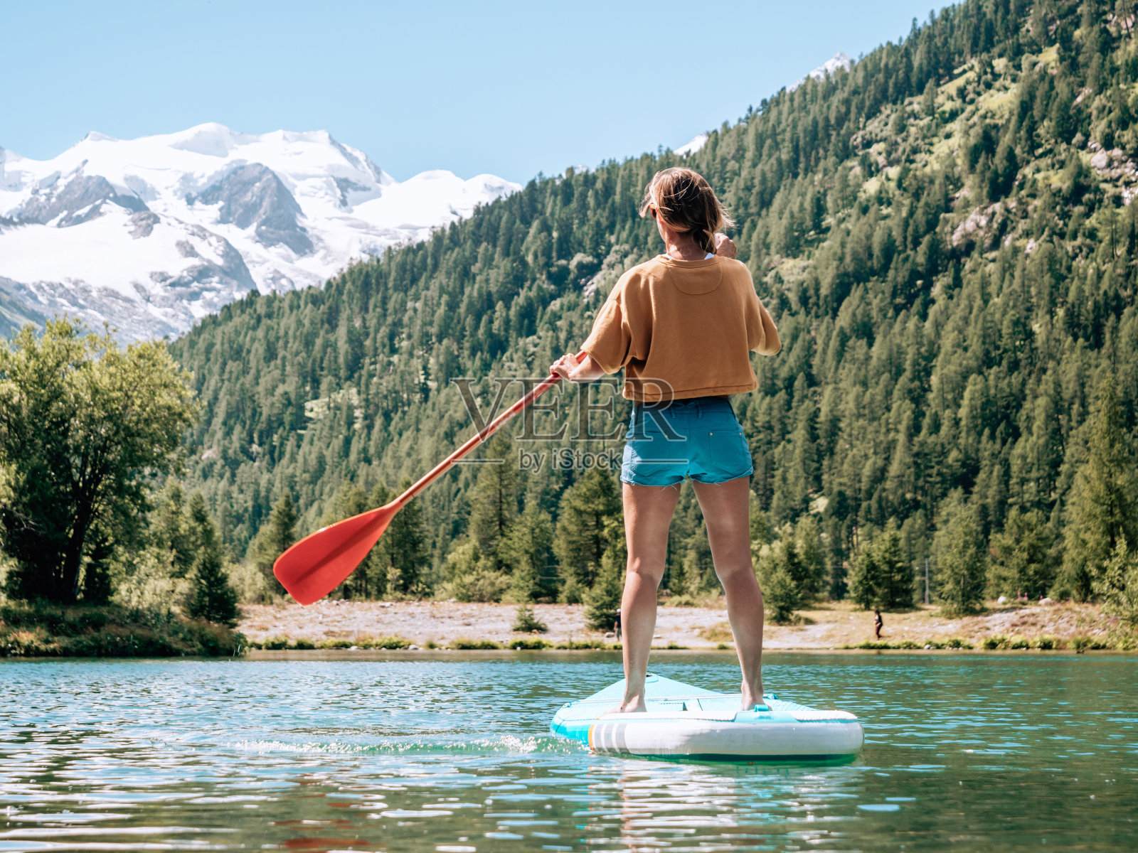 站起来划桨看风景，女人上SUP山看冰川照片摄影图片