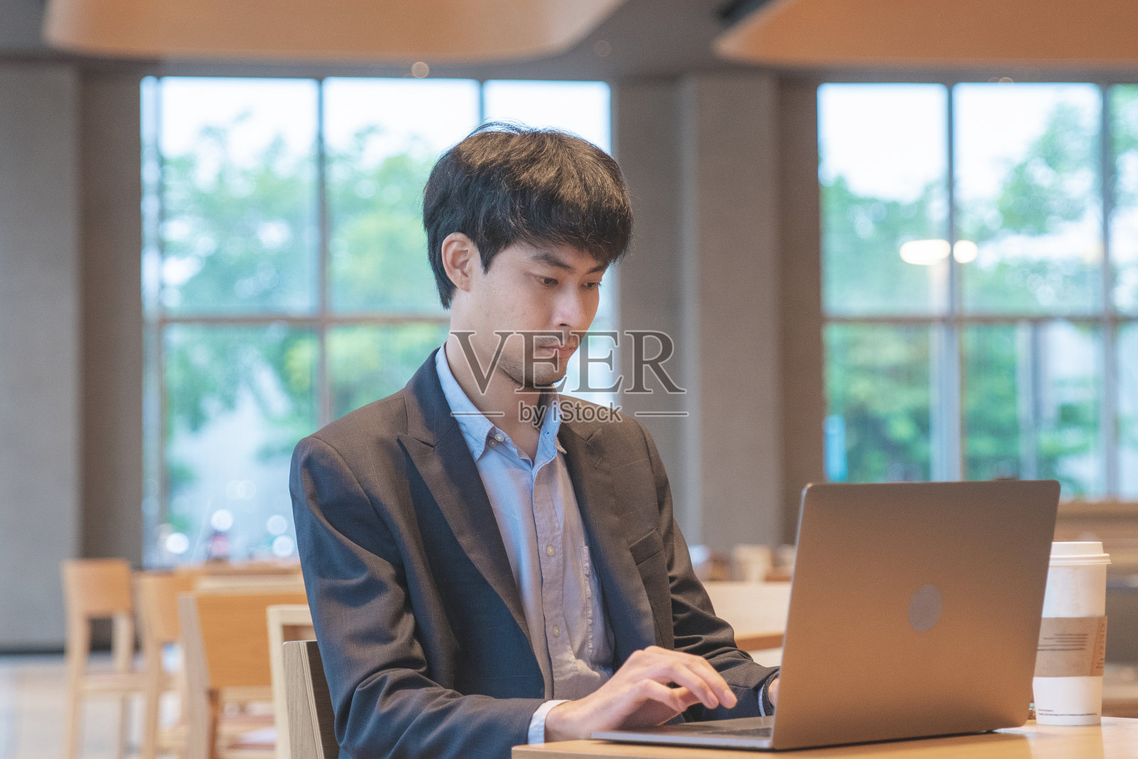 在现代办公桌旁工作的帅哥照片摄影图片