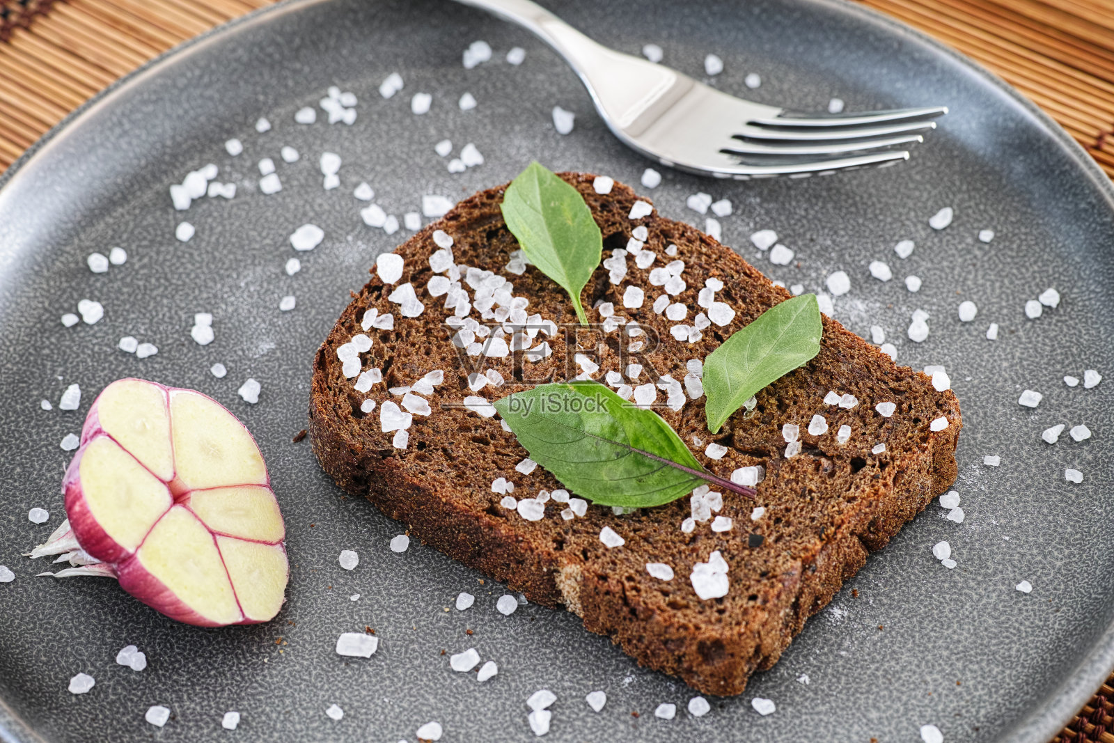 全谷物有机面包加海盐和罗勒叶照片摄影图片