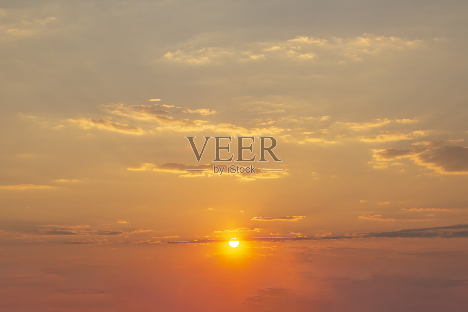 橙色的日落天空与太阳和轻云。照片摄影图片