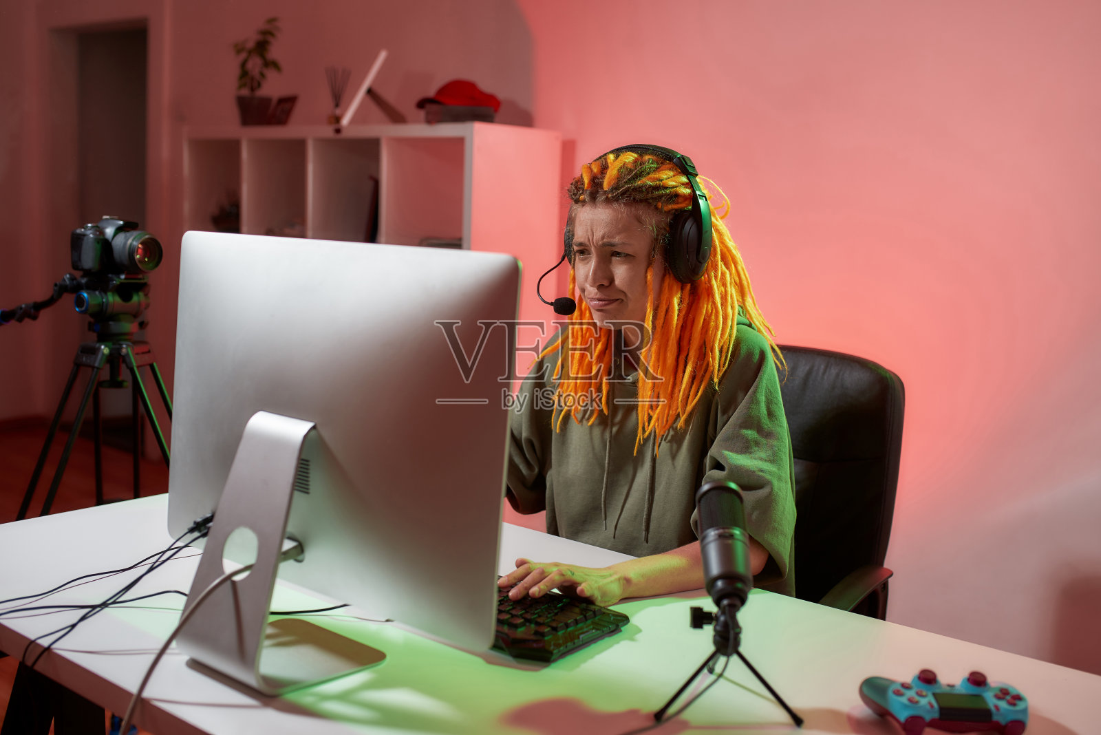 女电竞玩家，戴着耳机的女人看起来很沮丧，一边在电脑上玩在线视频游戏，一边在家里录制视频照片摄影图片