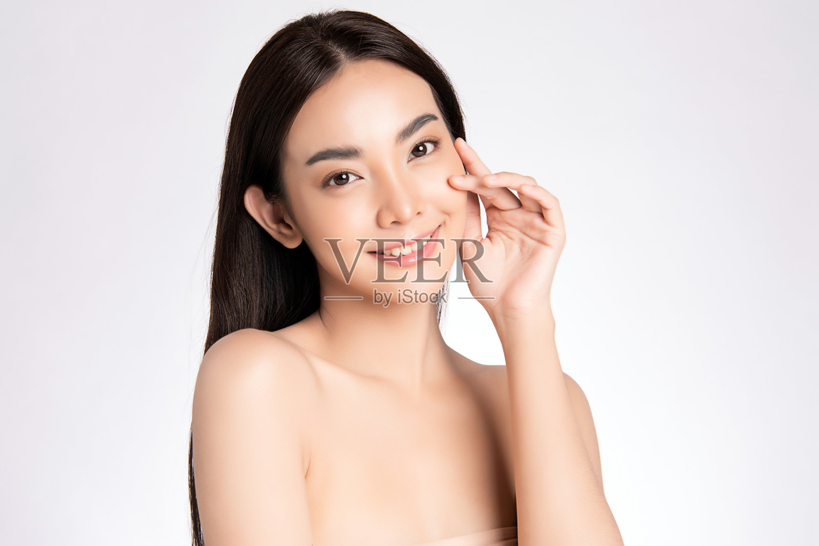 美丽年轻的亚洲女人与清洁新鲜的皮肤，在白色的背景，面部护理，面部治疗。美容、美容和水疗。亚洲女性肖像照片摄影图片