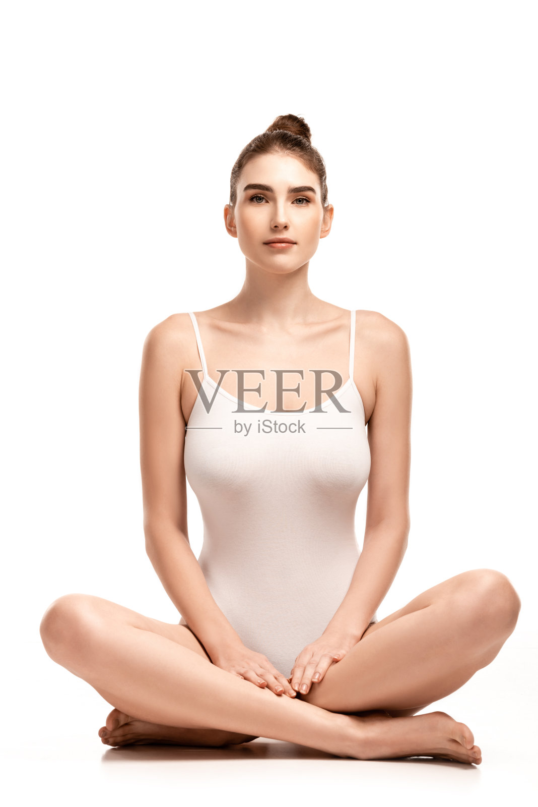 年轻女子穿着紧身衣坐在荷花的姿势在白色照片摄影图片