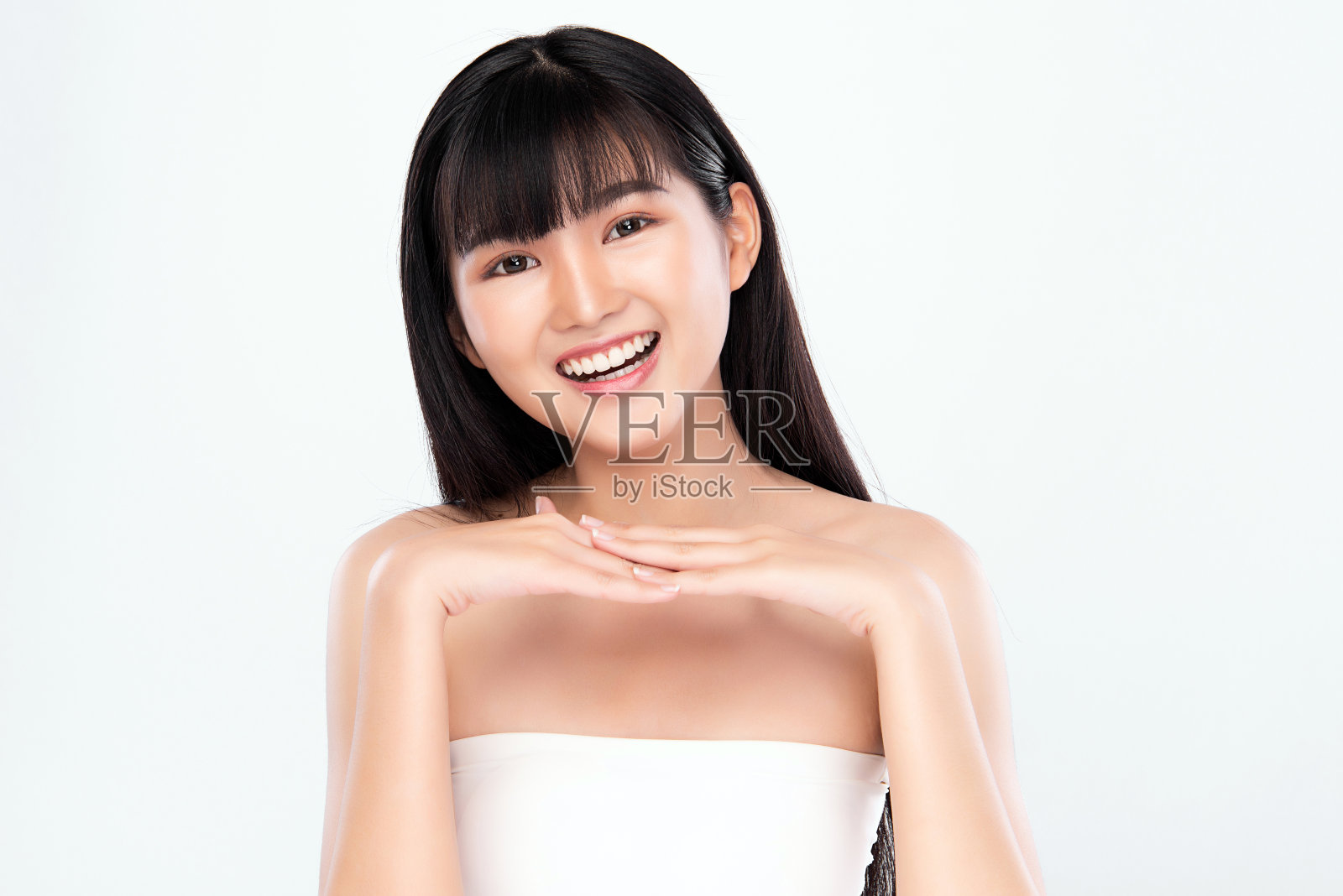 美丽年轻的亚洲女人与清洁新鲜的皮肤，在白色的背景，面部护理，面部治疗。美容、美容和水疗。亚洲女性肖像照片摄影图片