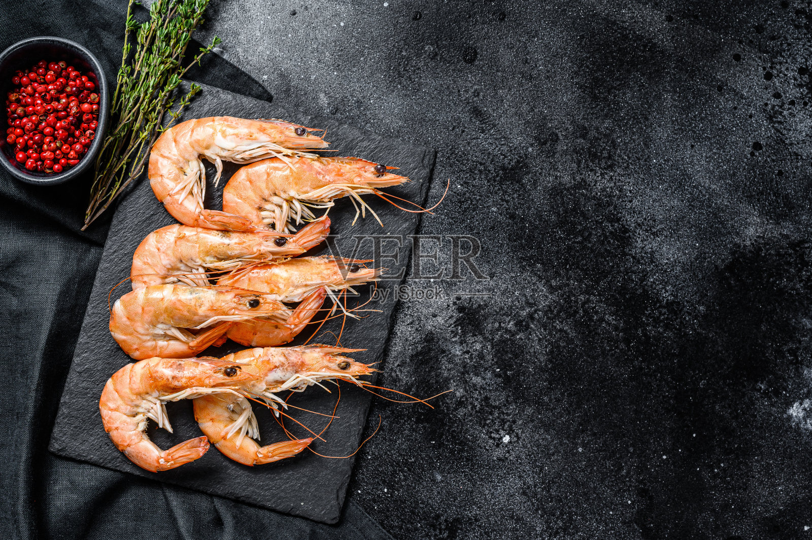 鲜煮大虾，虾仁放在石板上。黑色背景。前视图。本空间照片摄影图片