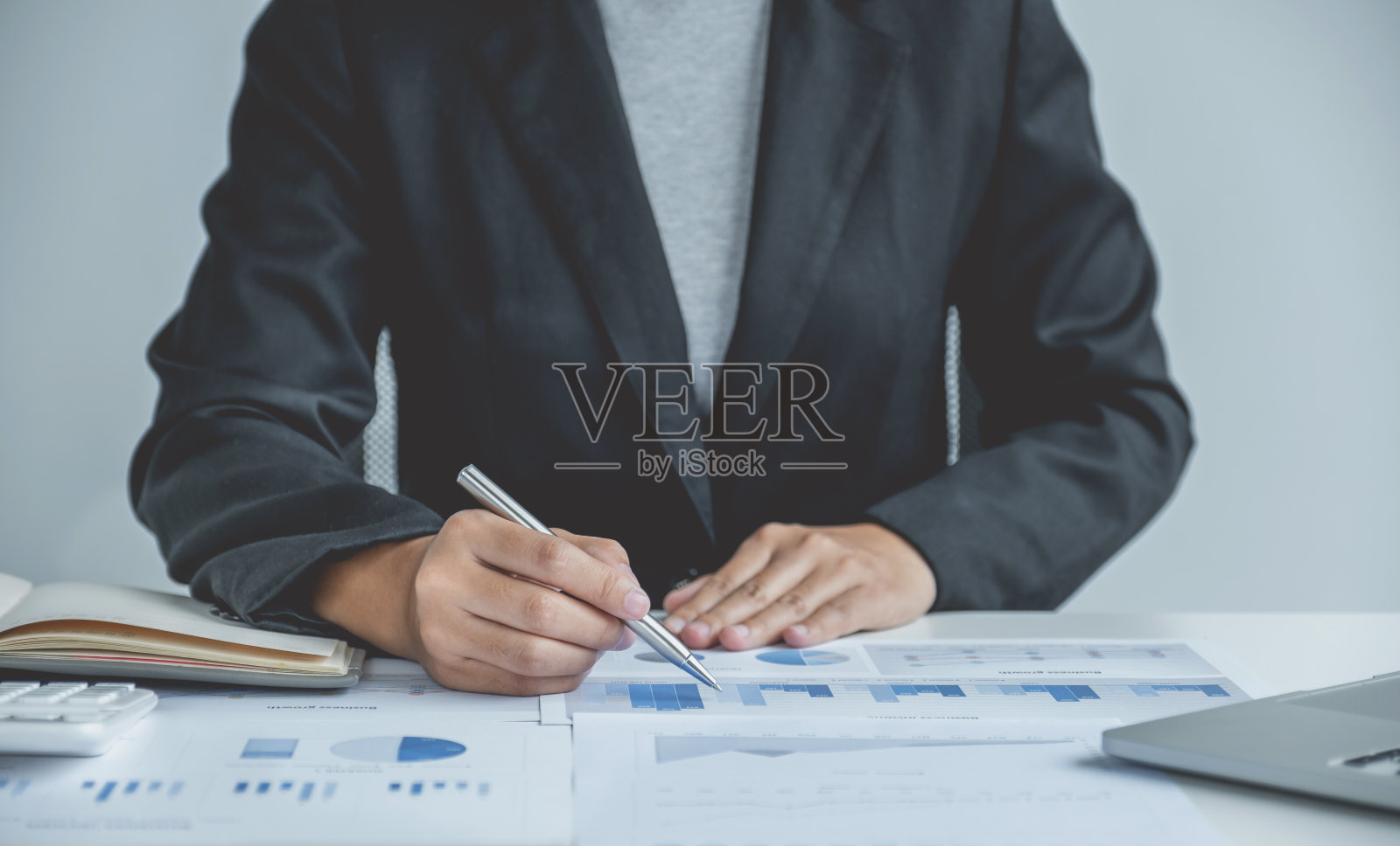 女商人在办公室用笔记本电脑分析图表来设定具有挑战性的商业目标，并计划实现新目标照片摄影图片