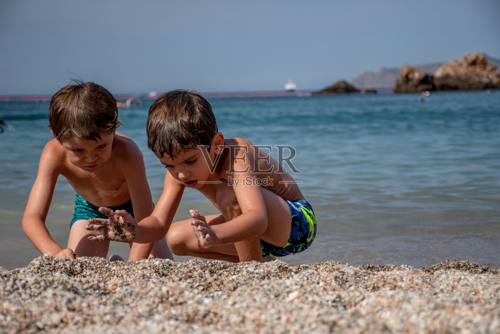 两个孩子在海滩上玩耍照片摄影图片