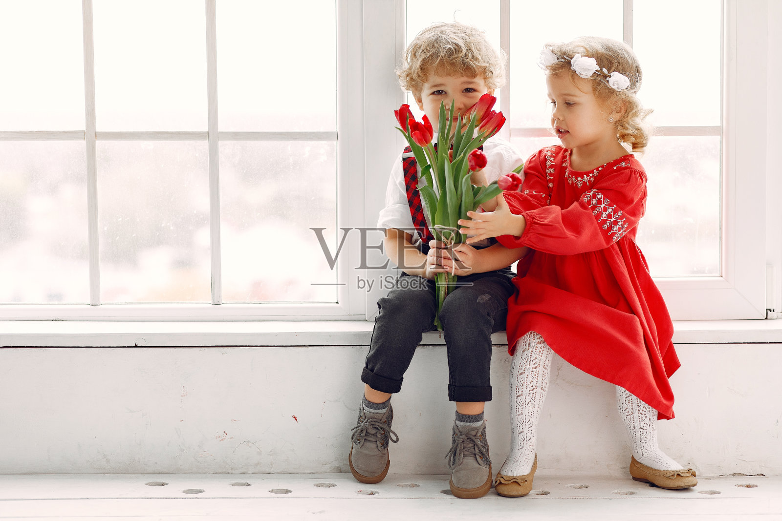 画室里优雅的孩子们捧着一束郁金香照片摄影图片