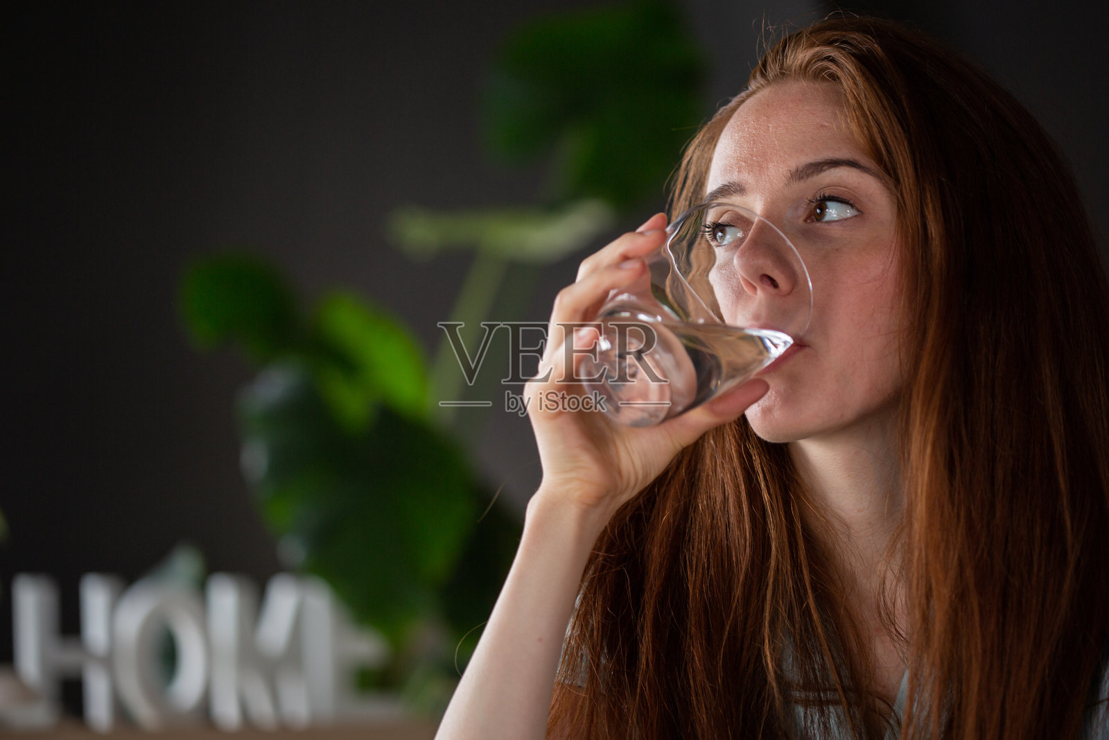 年轻女子在家里喝一杯水照片摄影图片