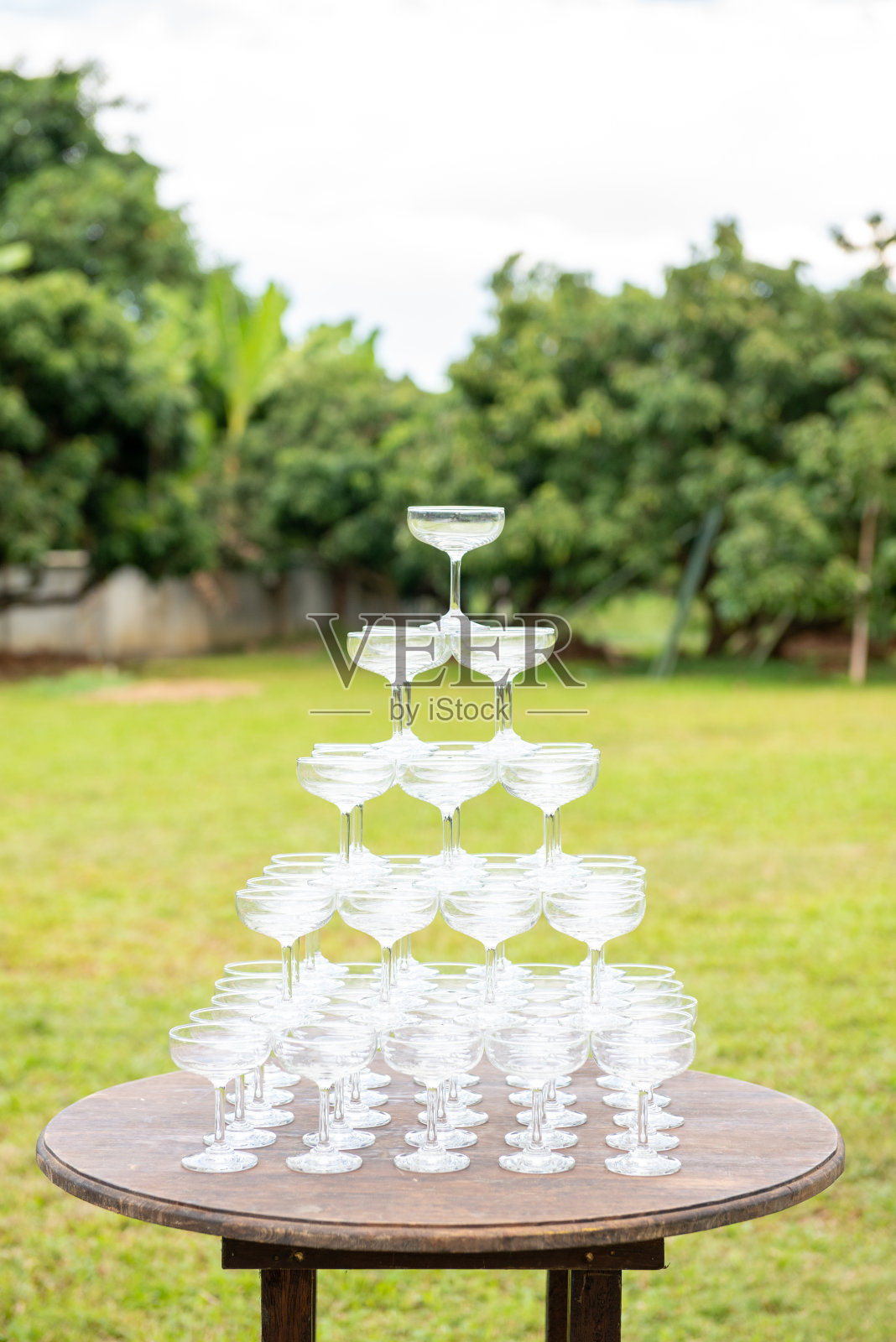 金字塔状的香槟酒杯堆放在户外的婚礼庆祝会照片摄影图片