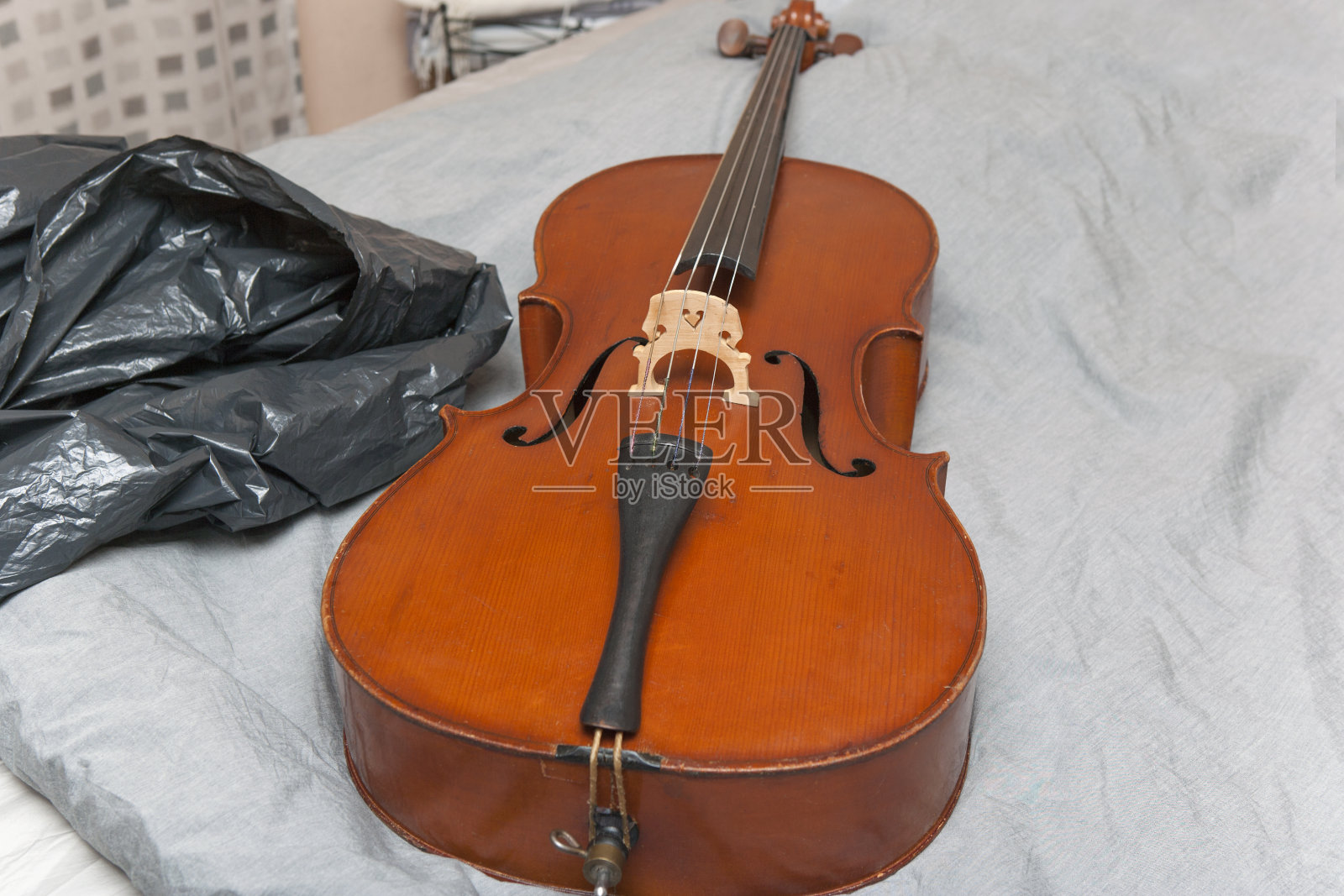 大提琴被遗弃在床上照片摄影图片