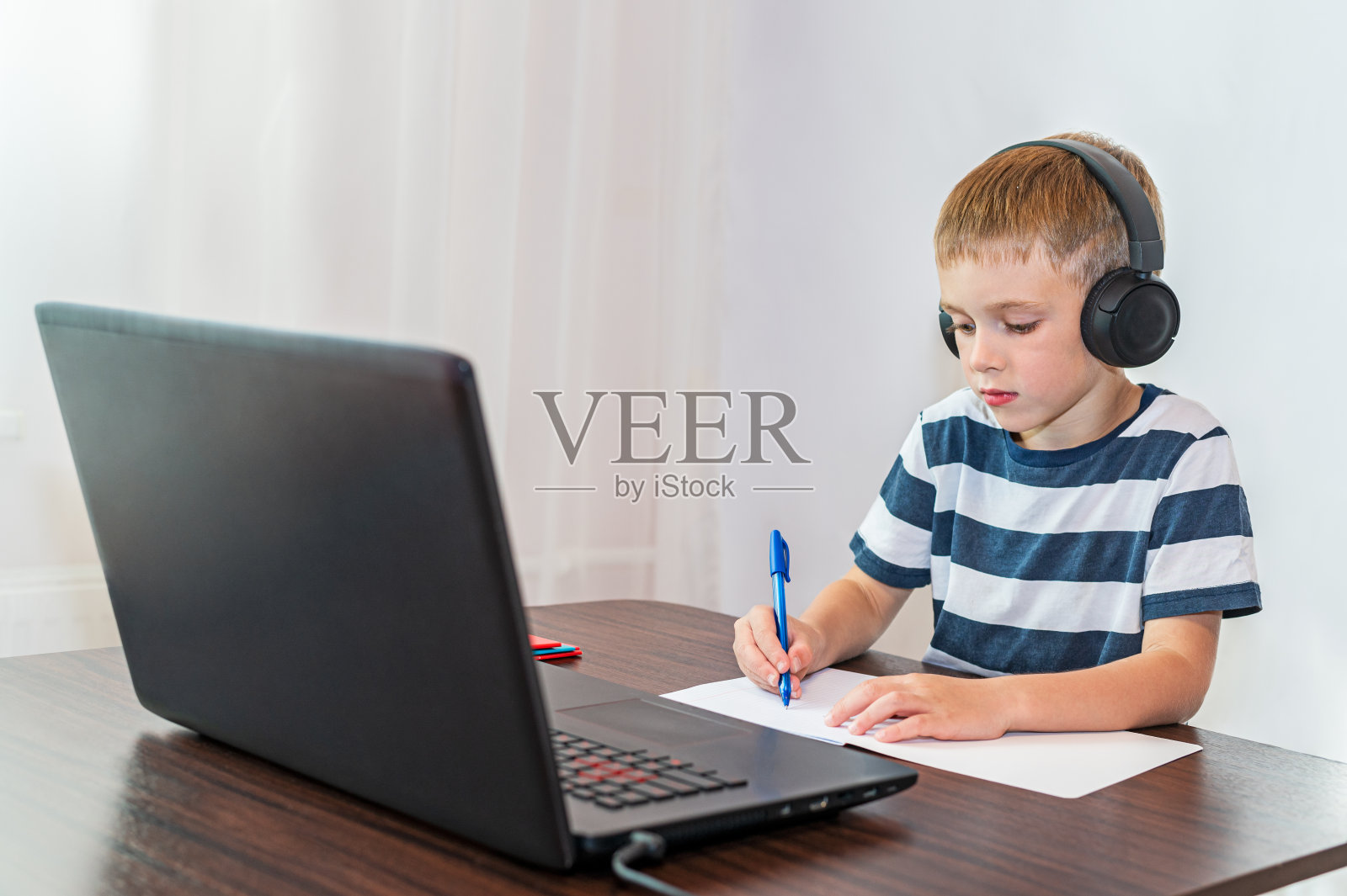 一个男孩在笔记本电脑前做作业。在线教育照片摄影图片