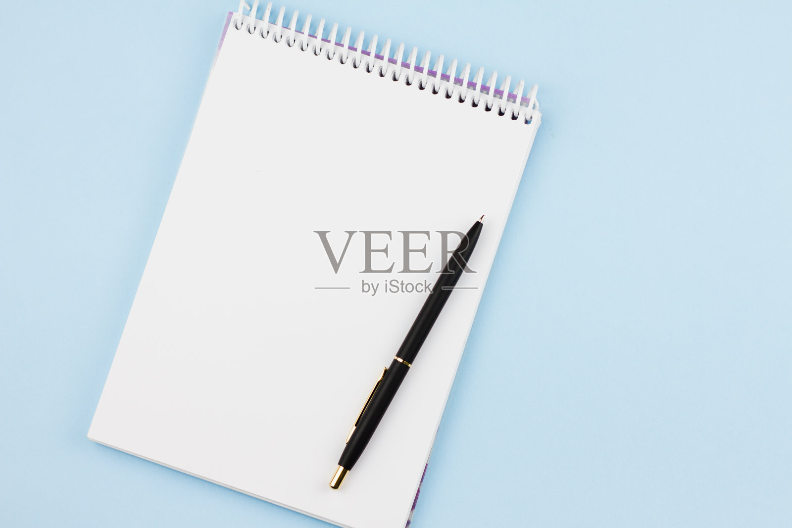浅蓝色背景的钢笔笔记本。照片摄影图片