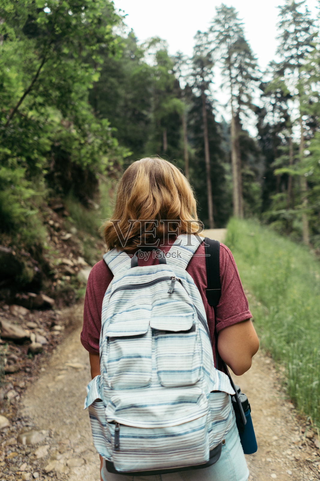 近距离女子与背包从背后看。夏天在附近徒步旅行的人。照片摄影图片