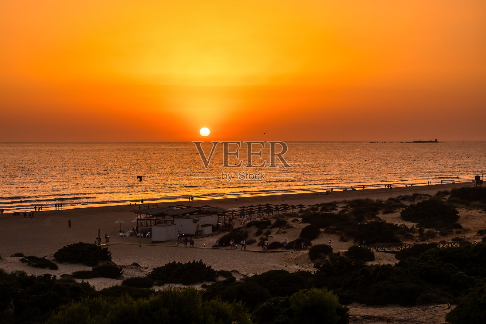 西班牙加的斯，圣佩特里，拉巴罗萨海滩上的日落照片摄影图片