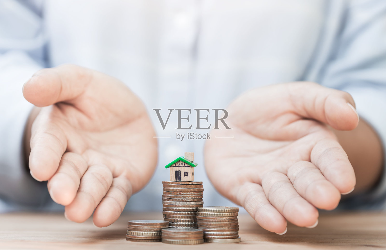 赠送房子和硬币的人的手。贷款的概念用于房地产、投资、买房。照片摄影图片