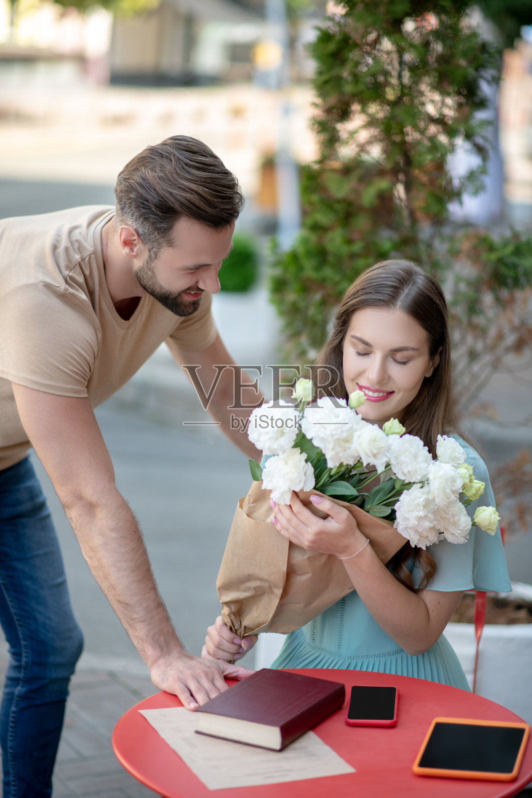 漂亮的女性拿着白花的花束由留胡子的女性照片摄影图片