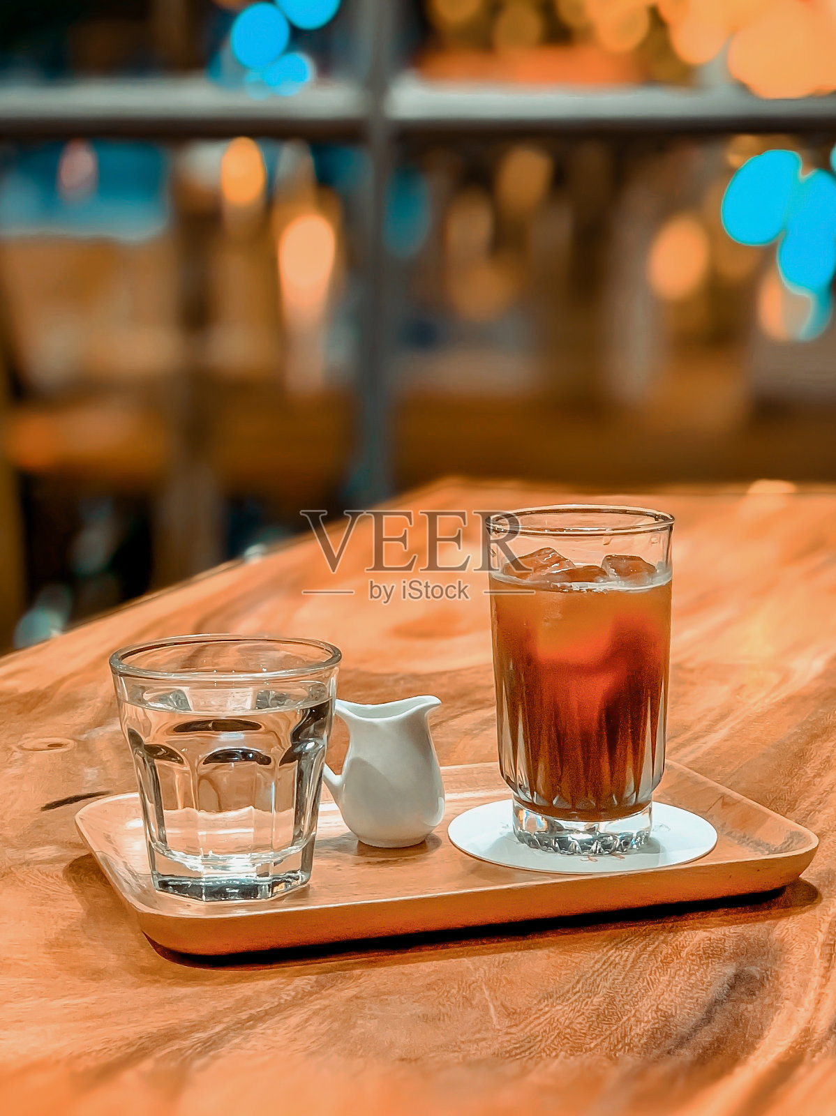 都市风格的咖啡店用木窗和玻璃装饰开敞空间，用手把糖浆倒进咖啡里照片摄影图片