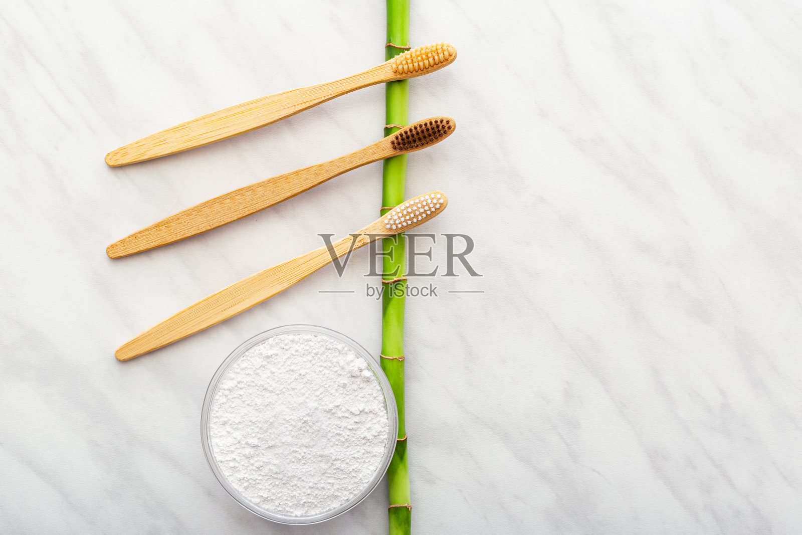 竹牙刷，竹植物牙粉，白色大理石背景。平铺拷贝空间。天然可降解竹牙刷。环保，零浪费，无塑料的理念照片摄影图片