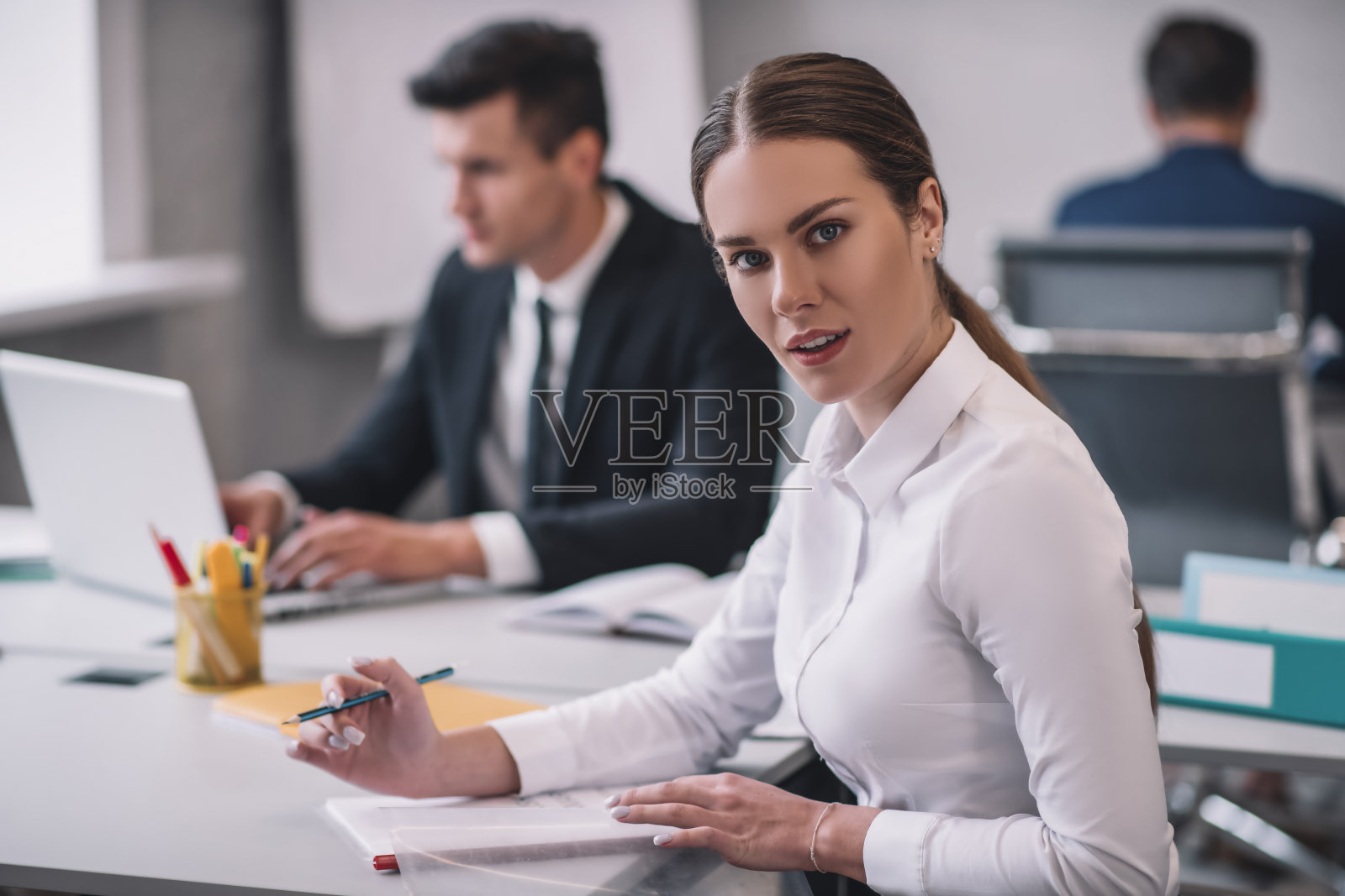 一位处理文件的成功女性和两位男同事照片摄影图片