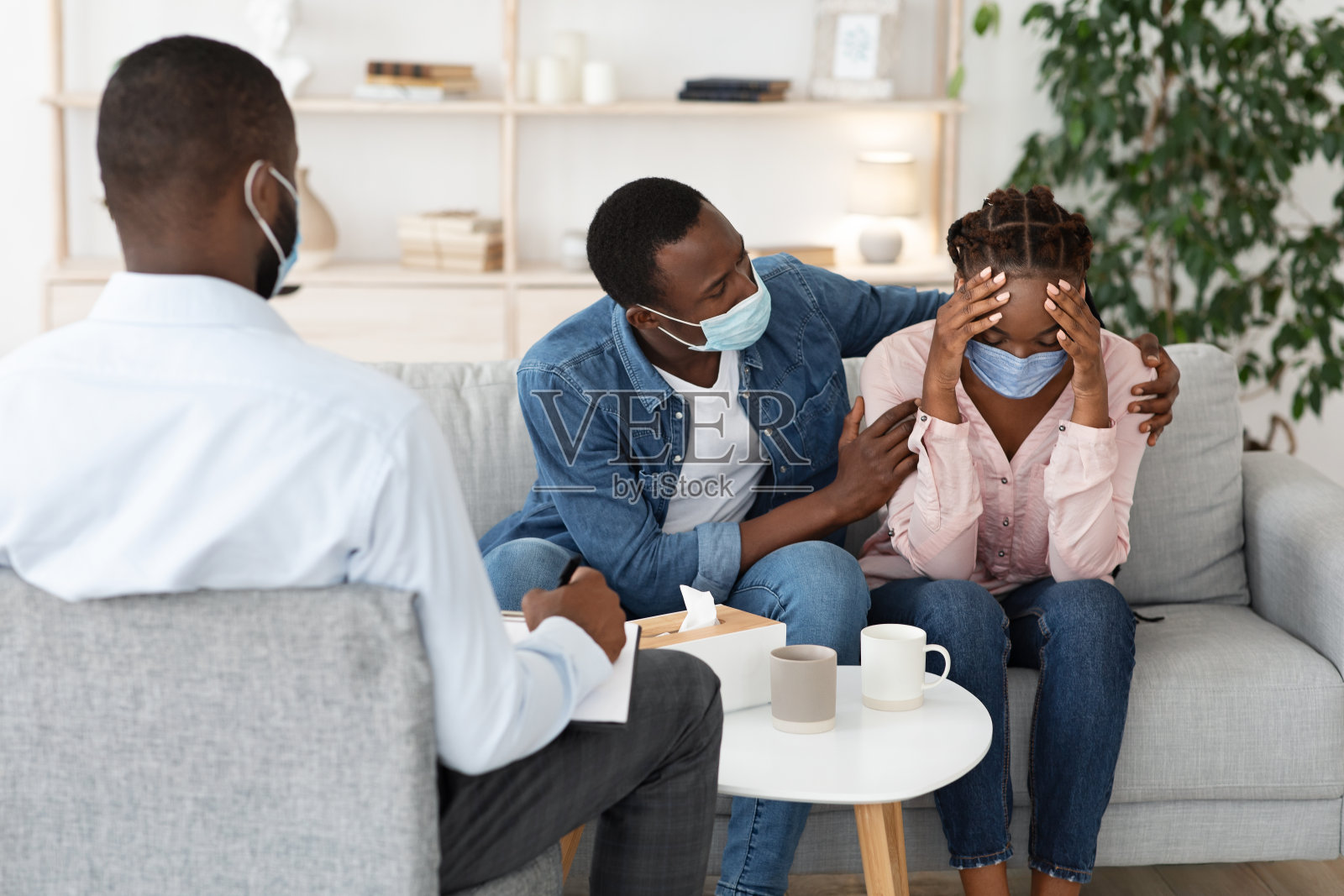 冠状病毒感染后，丈夫在心理治疗师办公室安慰妻子照片摄影图片