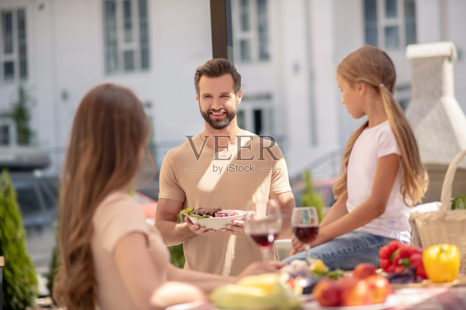父亲为他的妻子和女儿服务照片摄影图片