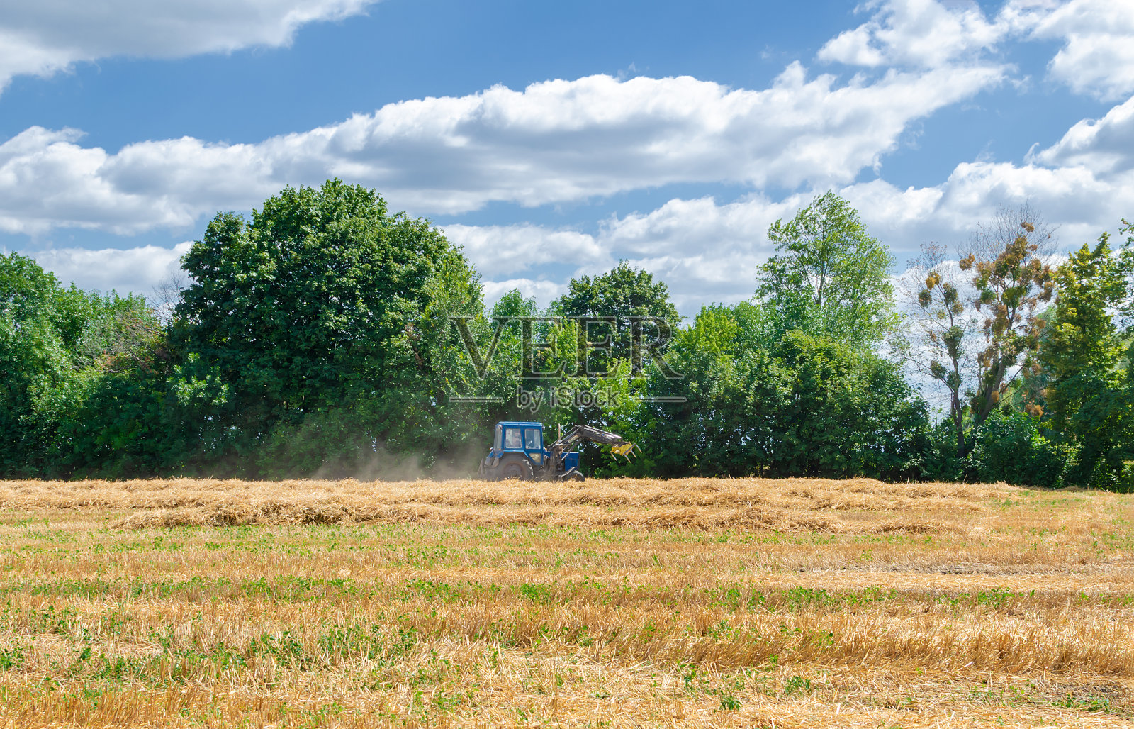 圆捆的稻草和田里的拖拉机照片摄影图片