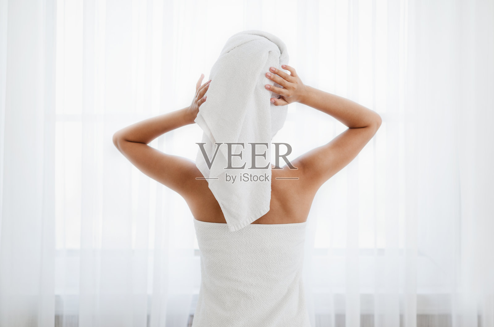 站在窗边裹着毛巾的女人照片摄影图片