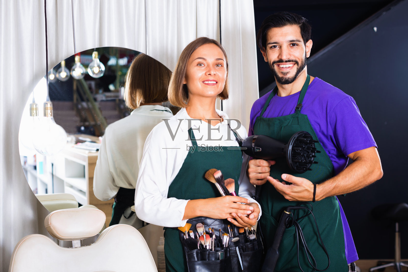 女化妆师和男发型师在沙龙里照片摄影图片