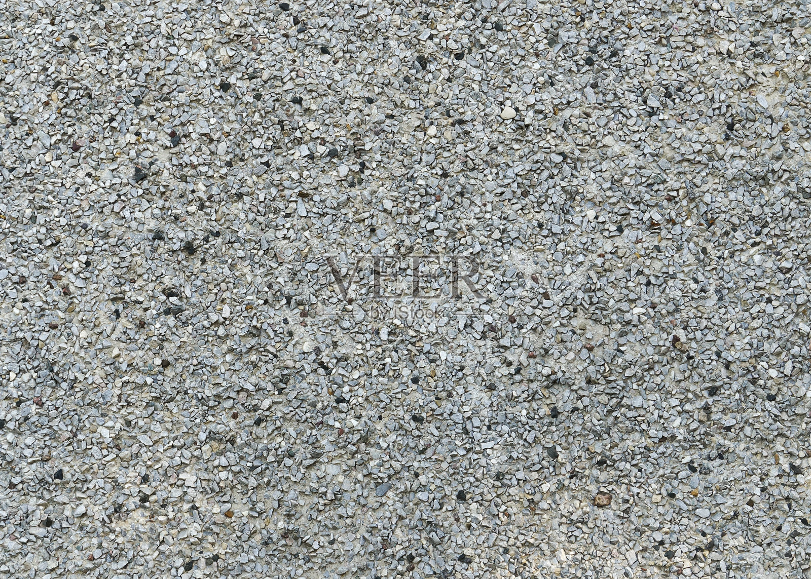 一个覆盖着灰色细砾石的混凝土表面的完整框架图像，一个面板建筑的外墙照片摄影图片