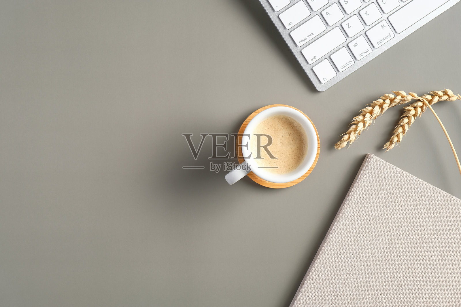 现代办公桌子桌上有咖啡杯，电脑键盘，小麦，纸笔记本。顶部视图与复制空间。平的。经营理念照片摄影图片