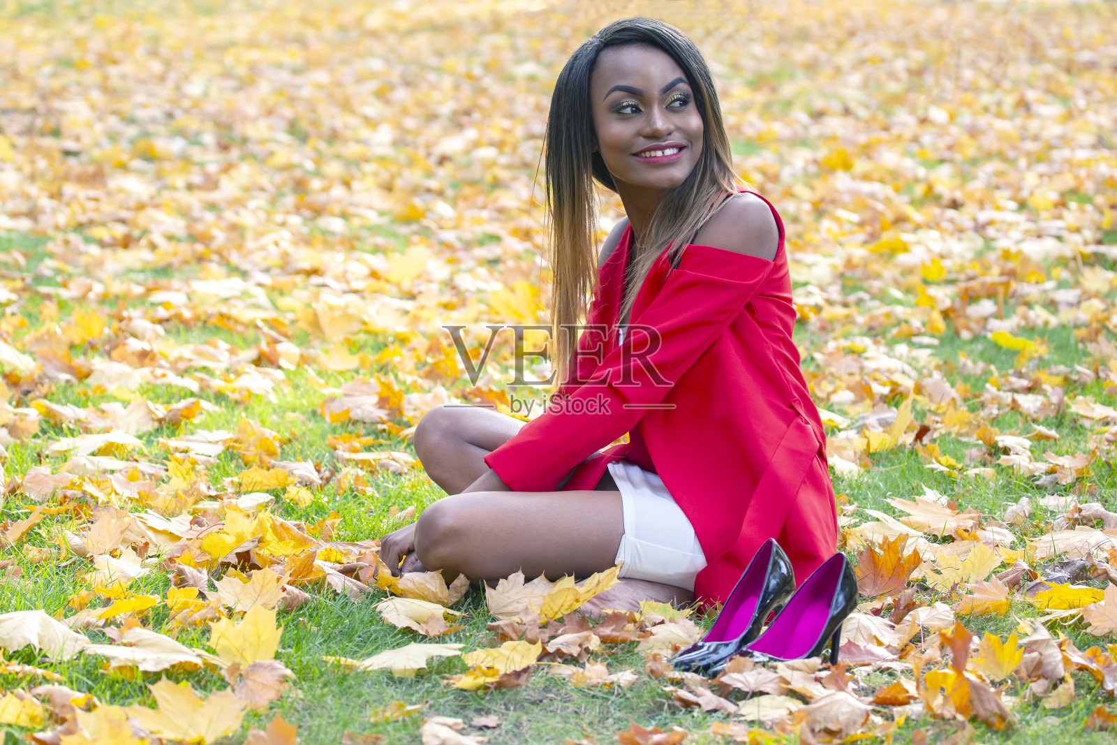 美丽的年轻非洲女孩在公园收集秋叶照片摄影图片