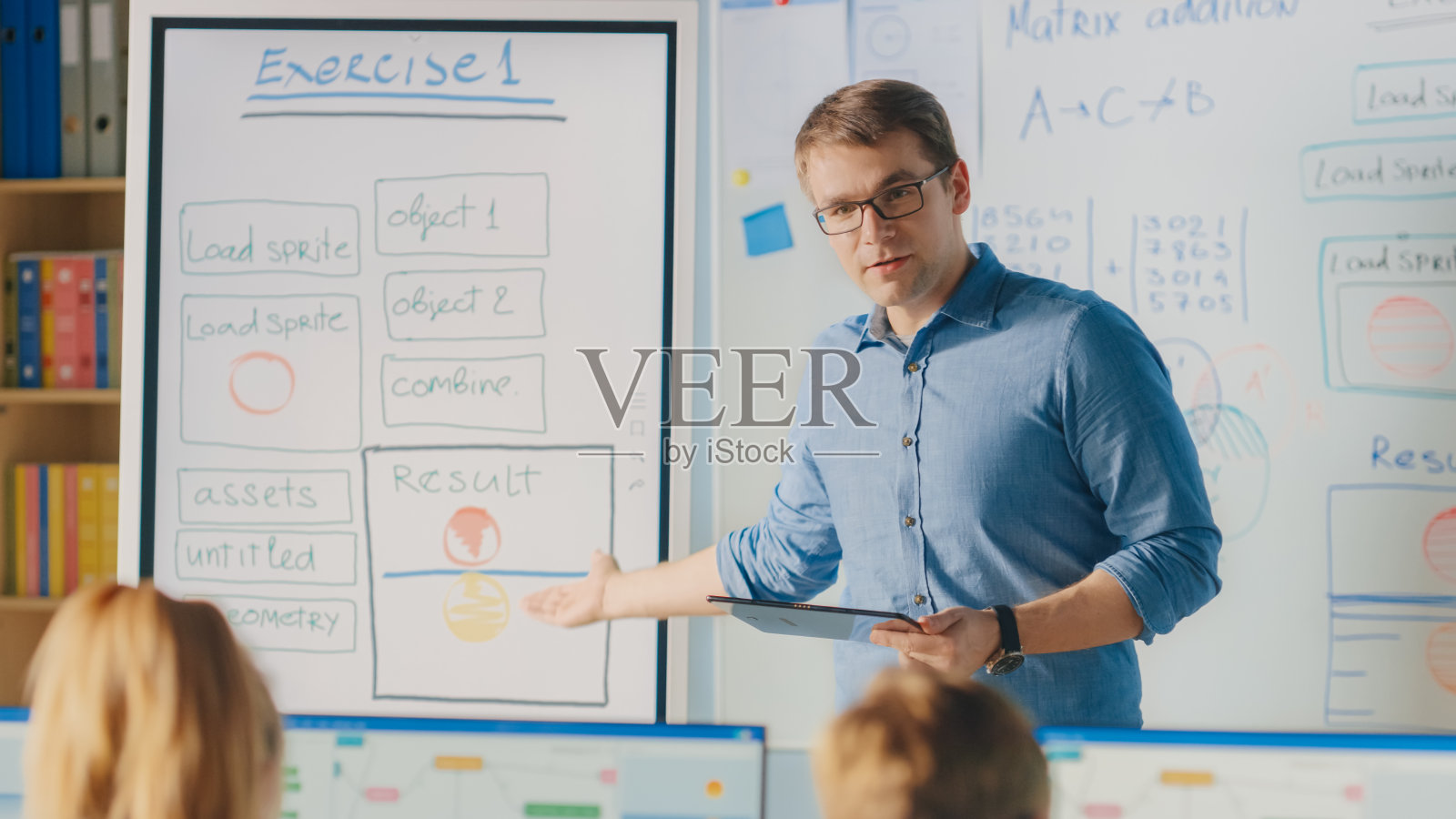 小学课堂:教师使用交互式数字白板，为多样化的聪明孩子讲解课程。孩子们接受现代教育，学习计算机科学，软件编程照片摄影图片