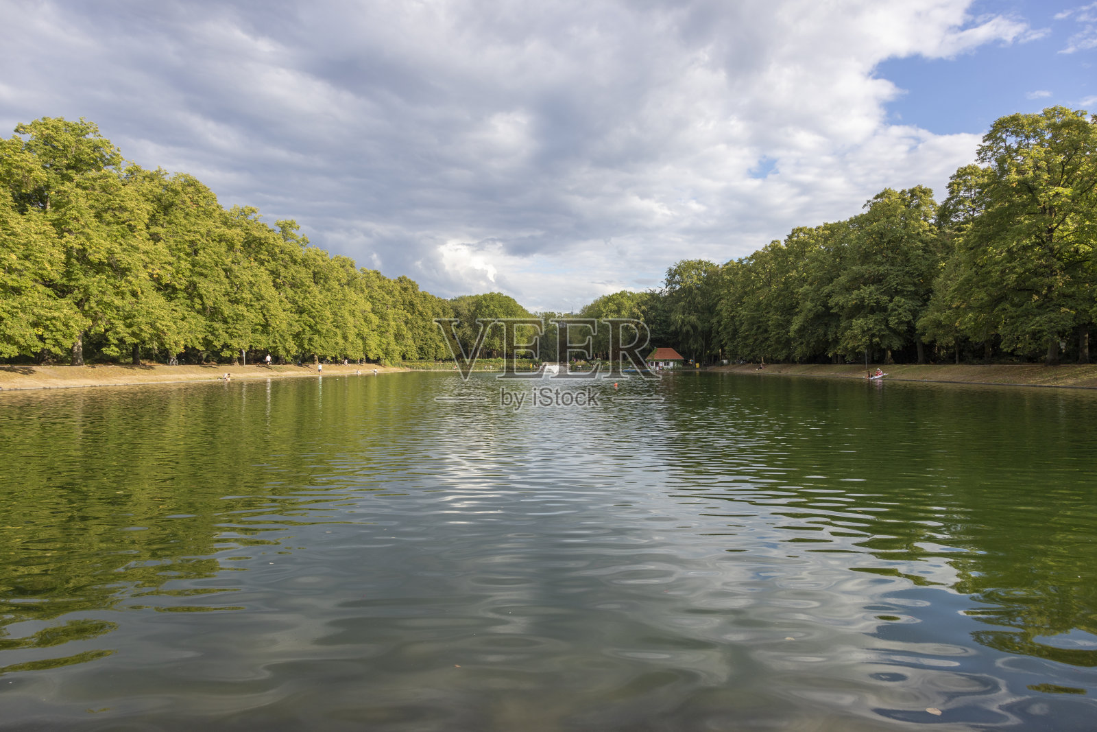 公园在科隆与一个湖与树木和干燥的草地，人们在背景，蓝精灵公园照片摄影图片