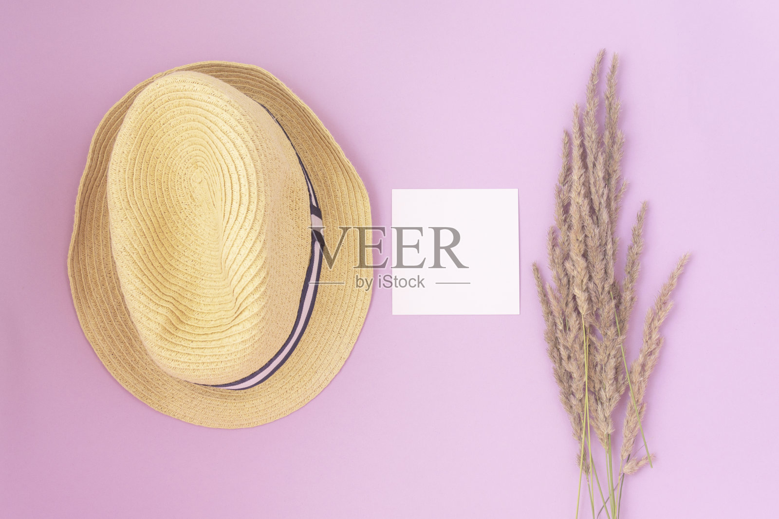 草帽和粉红色背景上的野花。夏天的概念。平躺照片摄影图片