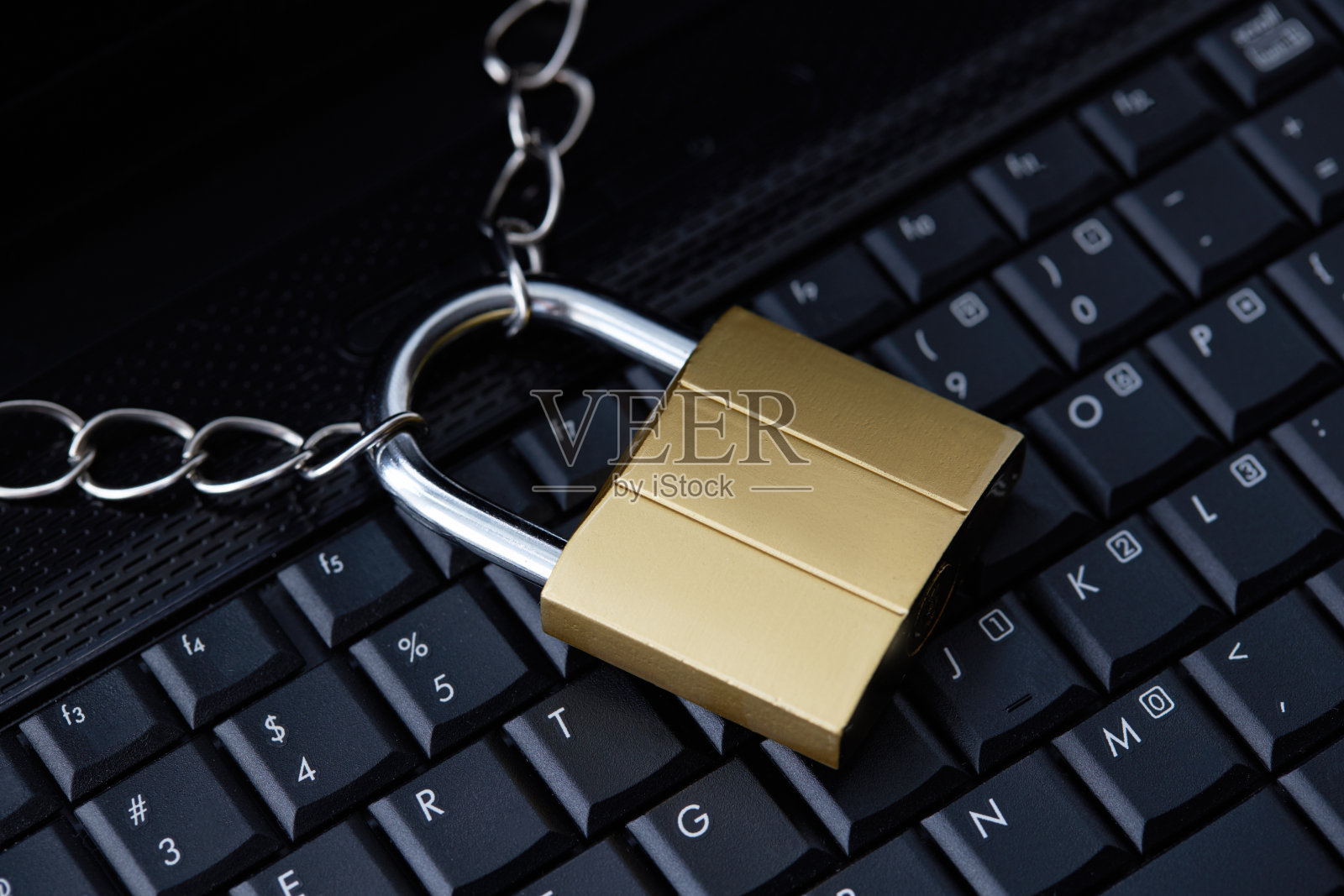 黑色笔记本键盘上的金色挂锁。网络安全的概念。杀毒软件的概念。电子钱包象征照片摄影图片