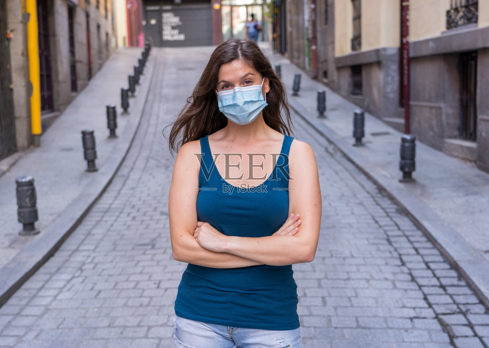 在公共场所戴口罩的年轻女子。冠状病毒传播防护口罩，可预防流感病毒和疾病。新冠肺炎后新常态生活的积极形象照片摄影图片