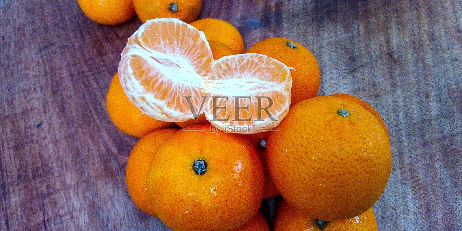 橙子和一个未剥皮的木材背景照片摄影图片