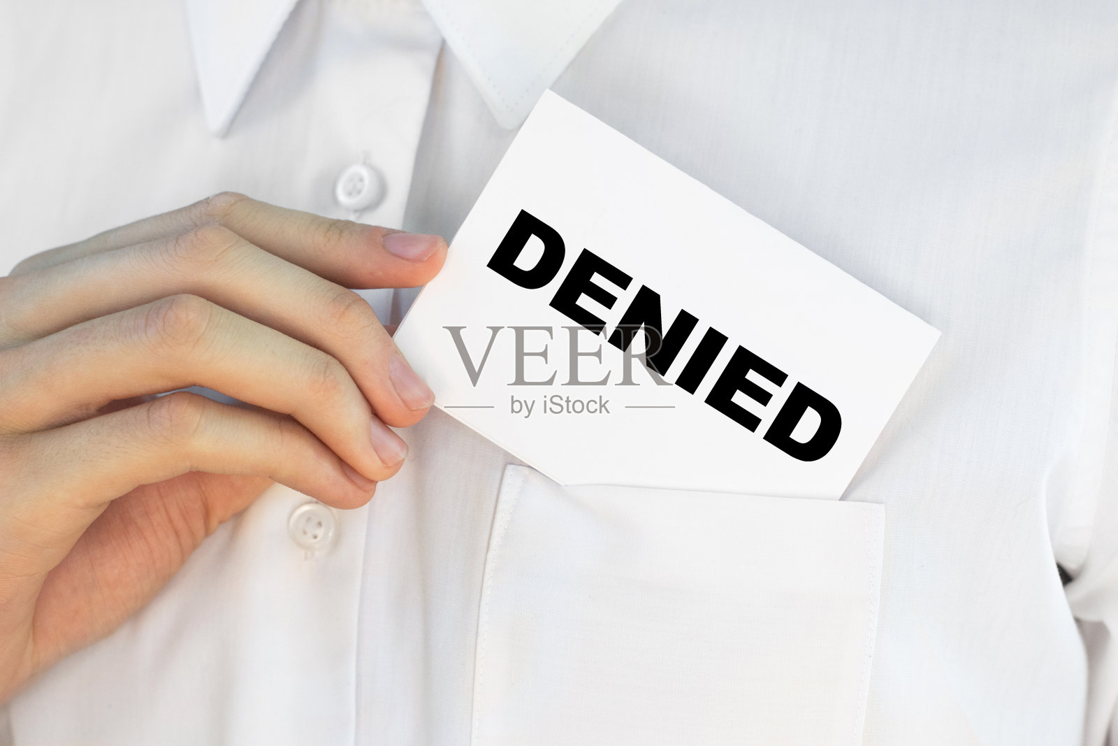 商人把一张写着拒绝的卡片放在口袋里照片摄影图片