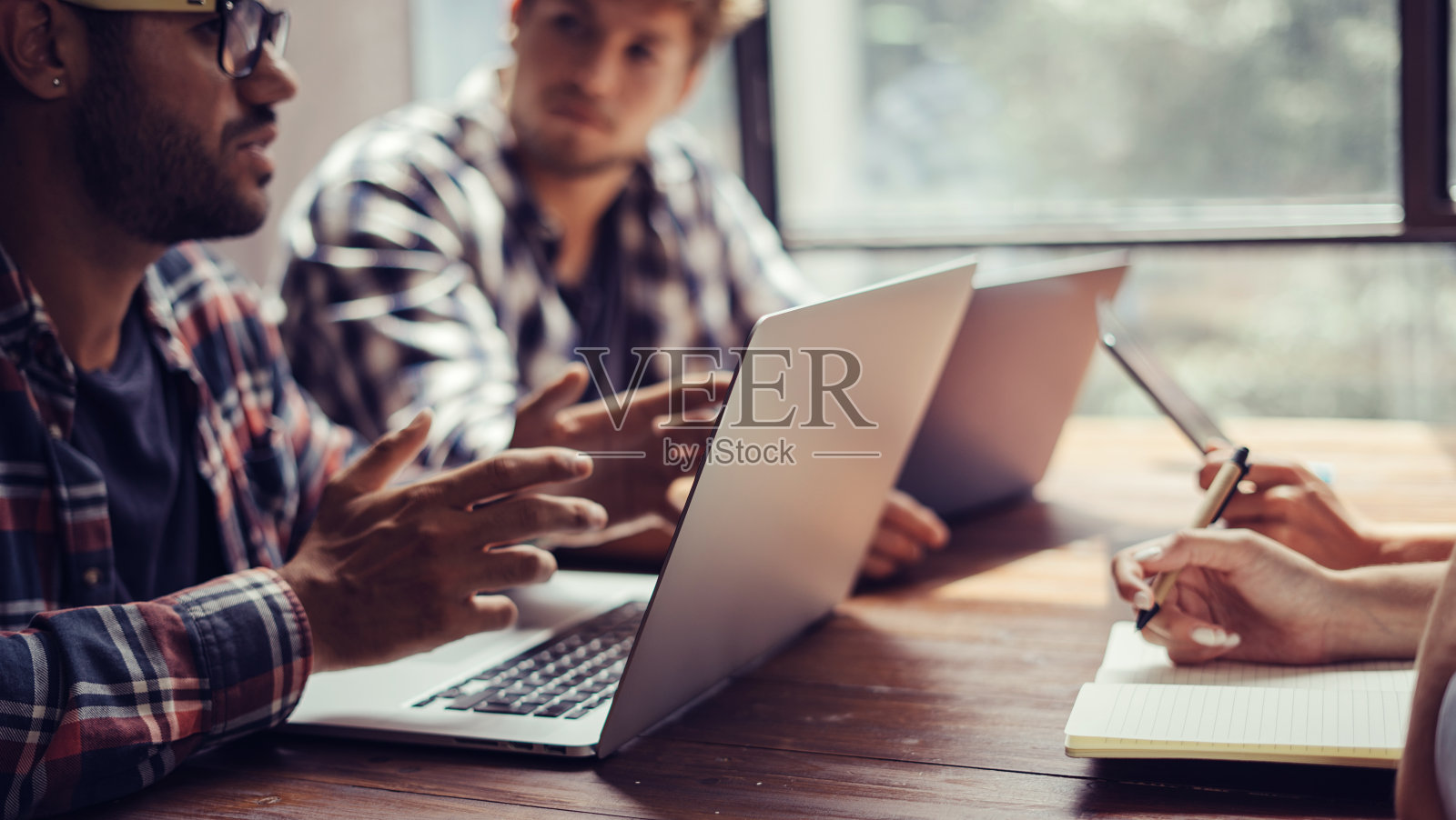 一群年轻人一起工作。现代办公室里有创意的商务人士。共同工作的潮人团队。现代年轻的同事。照片摄影图片