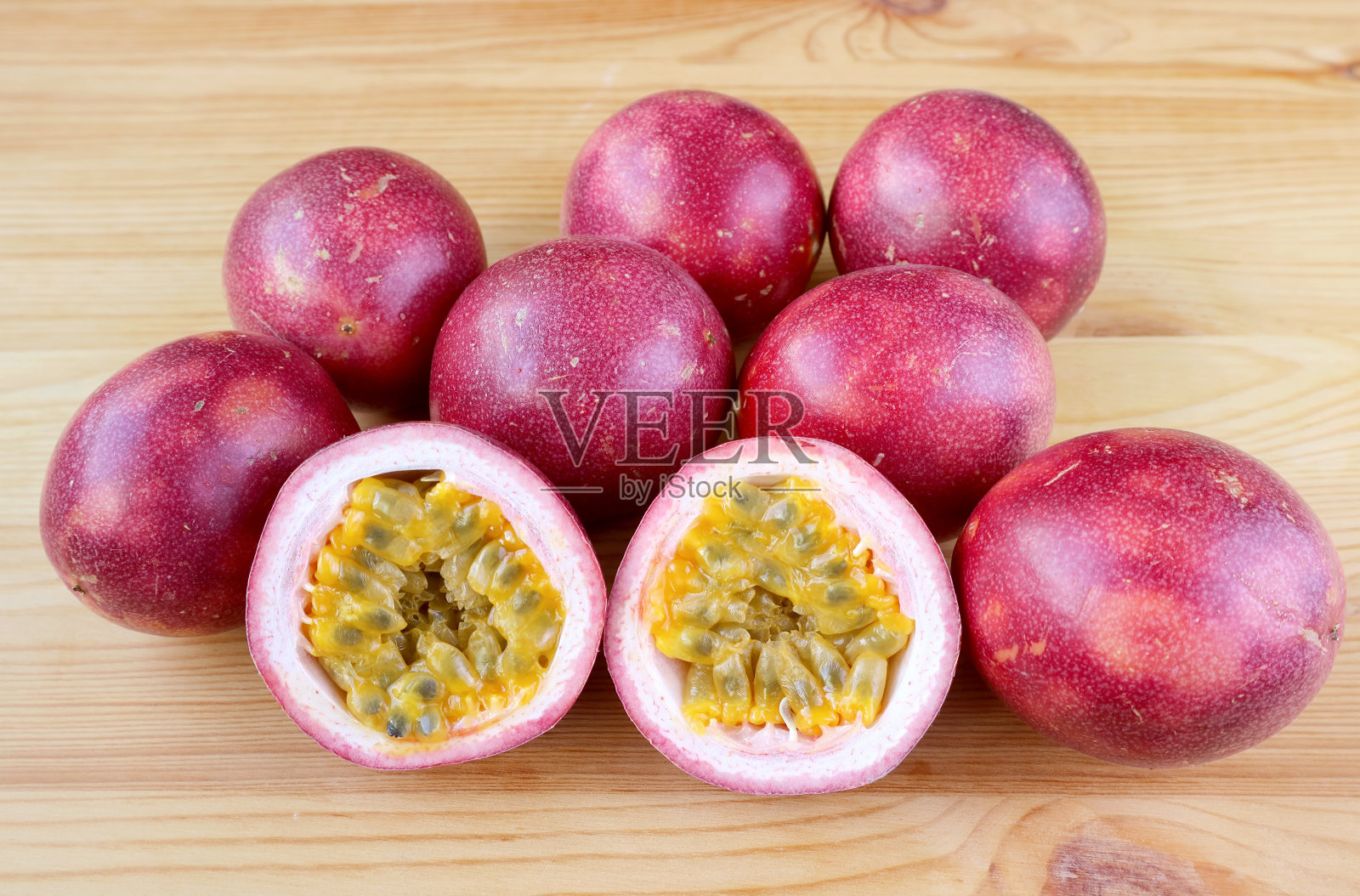 一对切成一半的新鲜的成熟的百香果与一堆完整的水果孤立在背景照片摄影图片