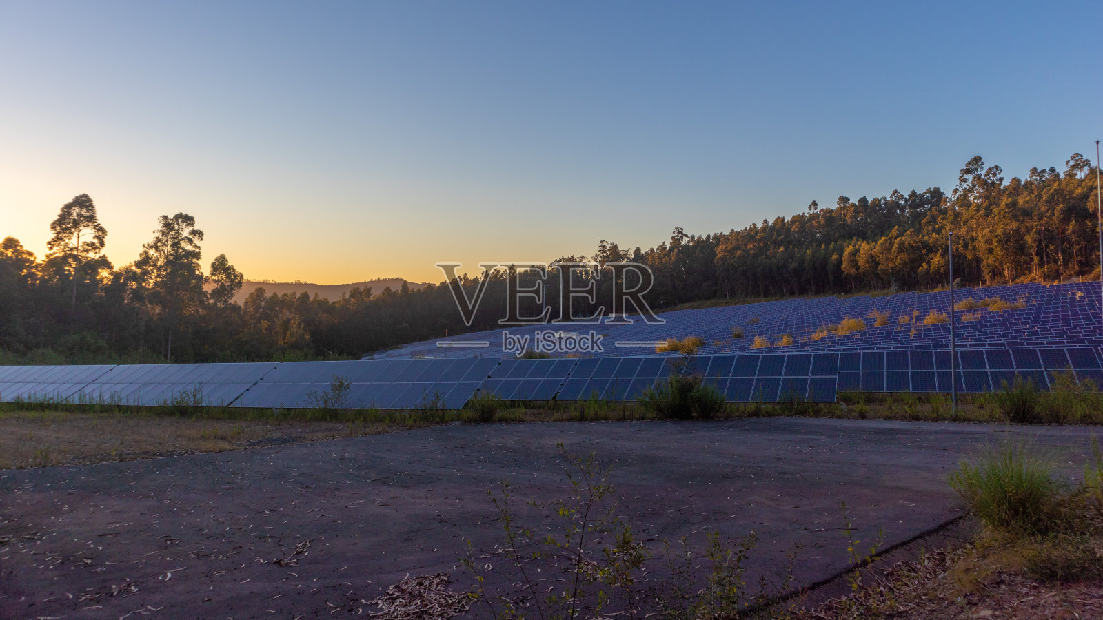 太阳电池板组在日落，在黄金时间照片摄影图片