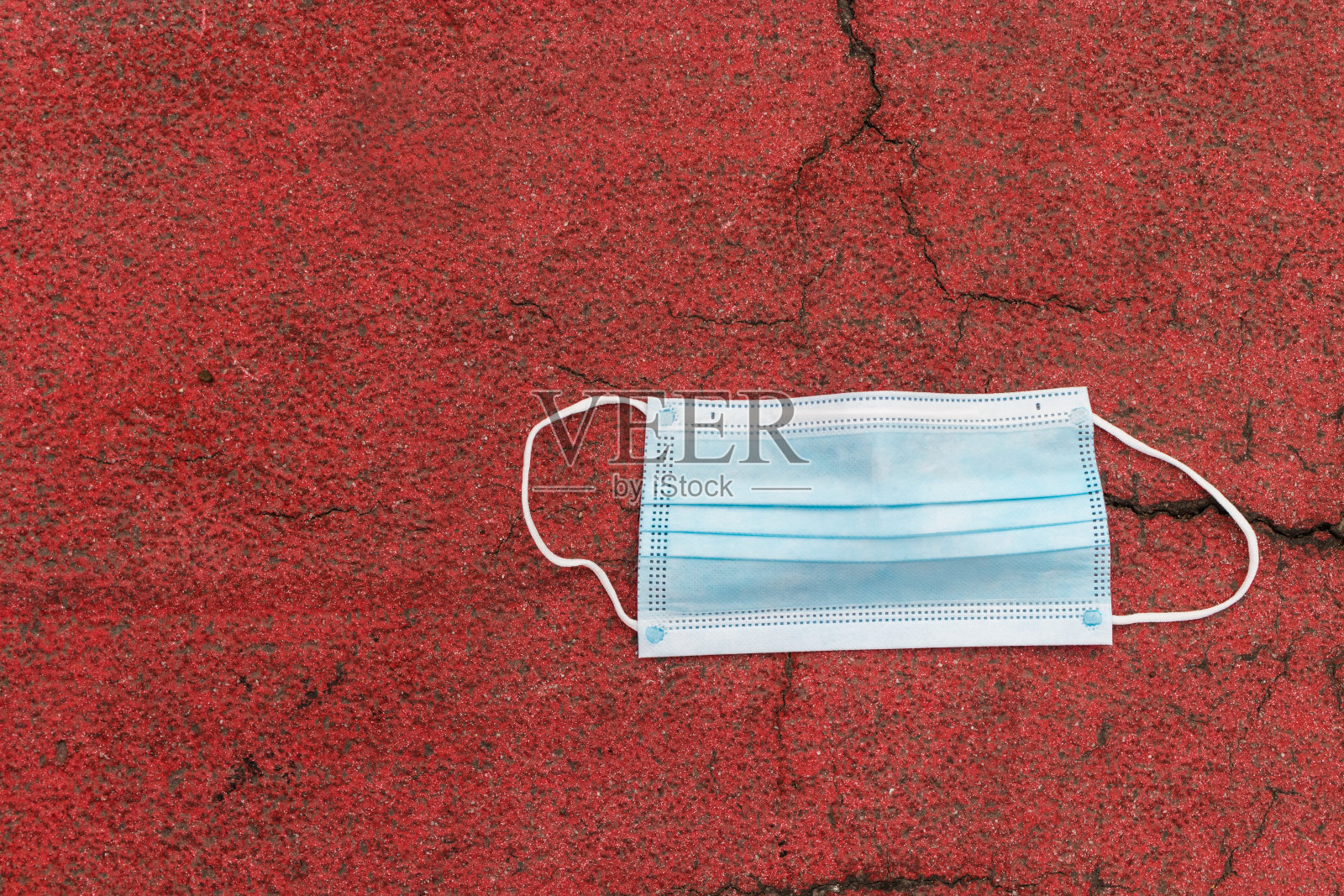 用过医用防护口罩扔在地板上。照片摄影图片