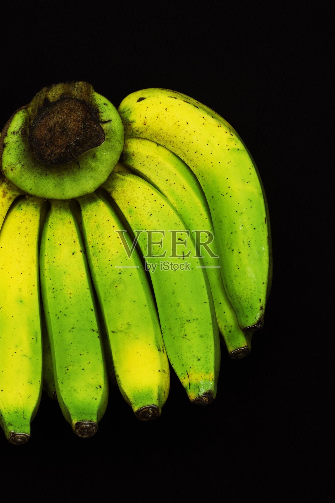 封闭的部分绿色香蕉变黄成熟。照片摄影图片